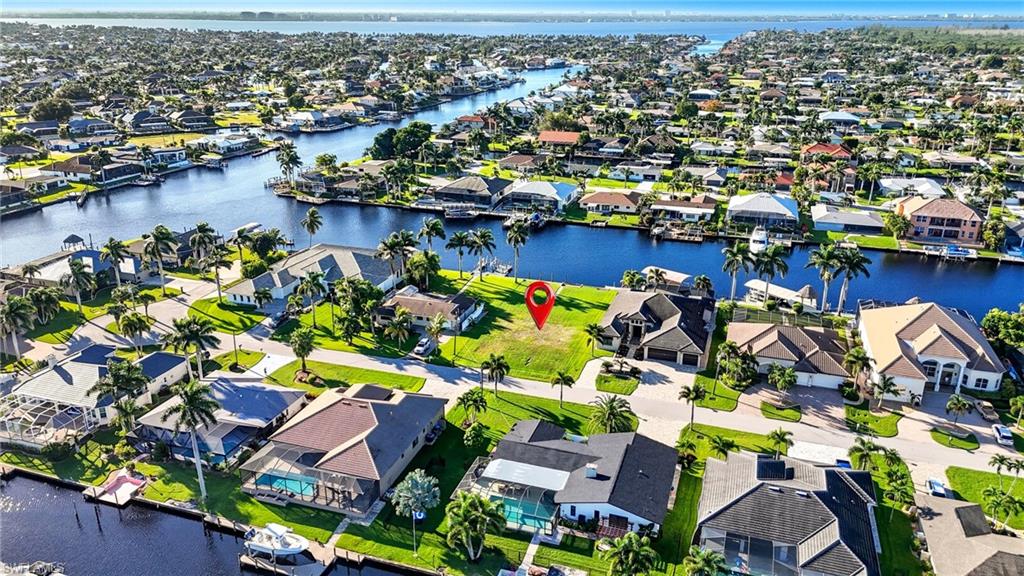 Unique opportunity to build your dream home on one of the few remaining true sailboat-access lots in Cape Coral’s coveted SW waterfront corridor. This oversized 12,000+ sq ft (80'x156') homesite offers an impressive 190-ft wide canal with a 14-ft deep water channel—just 15 minutes to the river with no bridges or locks to slow your route to open water. Nestled at the end of a quiet cul-de-sac of waterfront homes, this prime location offers both privacy and prestige. The southern rear exposure provides sun-filled days and stunning sunset reflections off the water—perfect for a future resort-style pool and outdoor living space. Enjoy the convenience of being centrally located between Cape Harbour and Tarpon Point Marina, where you’ll find waterfront dining, shopping, and boating amenities at your fingertips. With a seawall already in place, your build process is simplified and your vision can take shape immediately. Opportunities like this are rare—secure this exceptional property and design the luxury waterfront residence you’ve always imagined.