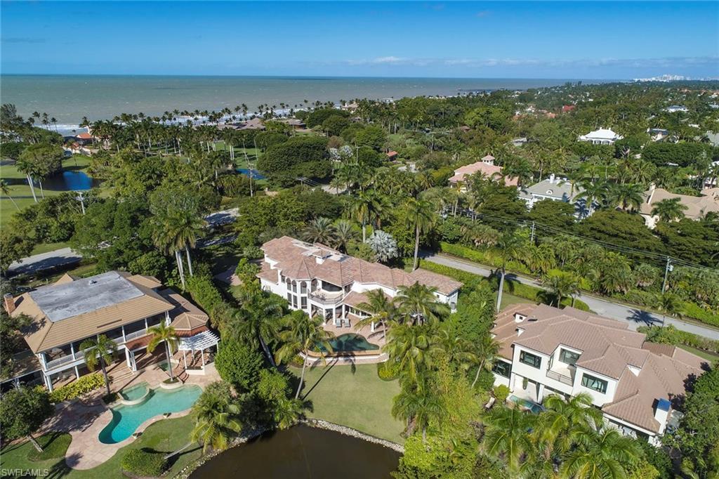 This one of a kind estate commands breathtaking, southern facing, panoramic water views of Lantern Lake in Port Royal. The elegant residence boasts a grand entry and expansive landscape featuring multiple gardens and car courtyard. The setting is tranquil and serene and offers extreme privacy. The presence of this home exudes quality craftsmanship throughout. From the moment you enter, the two-story great room captivates you. Featuring over 5,600 sq. ft. under air, 12’-24’ ceilings, 5 ensuite bedrooms, 6 full baths, and powder bath. The home also includes a lakeside library, 3 car garage, and a private elevator. Designed with two master suites, one on the first floor and a grand master suite on the second floor with balcony overlooking the lake. The chef’s kitchen is equipped with high end appliances and is adjacent to the breakfast room and large family room with sliding doors to the outside terrace. The large outdoor terrace with summer kitchen sits next to the infinity edge pool and spa providing plenty of room for entertainment. Port Royal Club membership eligible.
