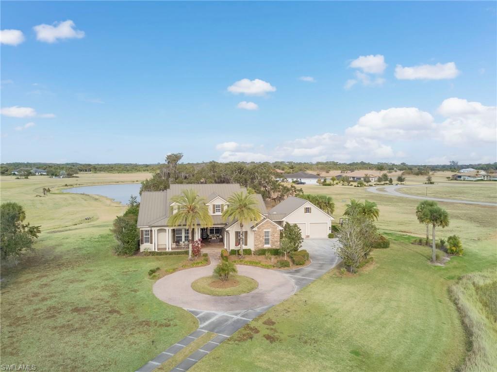 Experience luxury living in a prestigious gated riverfront community along the scenic Caloosahatchee River in charming Alva. Residents enjoy access to a private neighborhood boat ramp and dock, providing effortless boating, fishing, and the very best of the Southwest Florida lifestyle.

This exceptional custom-built Arthur Rutenberg estate is perfectly positioned on a private 1.48-acre homesite surrounded by tranquil ponds, creating a peaceful and picturesque setting. Thoughtfully designed with timeless architecture and quality craftsmanship, the home offers an open and inviting floor plan filled with natural light, elegant finishes, and spacious living areas ideal for both entertaining and everyday comfort.

Interior features include tile flooring throughout main living areas, tray ceilings, crown molding, Plantation shutters, a formal dining room, and a large den/home office with French doors. The gourmet kitchen is beautifully appointed with granite countertops, custom wood cabinetry, stainless steel appliances, center island, breakfast bar, and a sunny breakfast nook overlooking the pool and outdoor living space. The adjoining family room is lined with glass doors that seamlessly blend indoor and outdoor living.

The luxurious primary suite serves as a private retreat with tray ceilings, direct pool access, spacious walk-in closets, and a spa-inspired bath featuring a soaking jetted tub, walk-in shower, and dual vanities. The main level also offers several additional guest bedrooms plus a flexible bonus room with pool bath access, ideal for a guest suite, fitness room, or studio.

Upstairs, a large bonus/game room with built-in beds, pool table, and private balcony offers endless possibilities for recreation and entertaining.

Step outside to your own resort-style oasis featuring a sparkling pool and spa, custom outdoor kitchen, and cozy gas firepit surrounded by lush tropical scenery. Additional highlights include a durable metal roof installed in 2017, transferable low-cost flood insurance, extensive attic storage, and incredible garage space with a 2-car attached garage plus a separate 3-car garage connected by a breezeway.

For active lifestyles, enjoy your own private pickleball court and ample room to add an additional detached garage if desired. Conveniently located near the rapidly growing Babcock Ranch community with easy access to shopping, dining, LaBelle, and I-75, this remarkable property offers the perfect blend of luxury, privacy, and country charm.