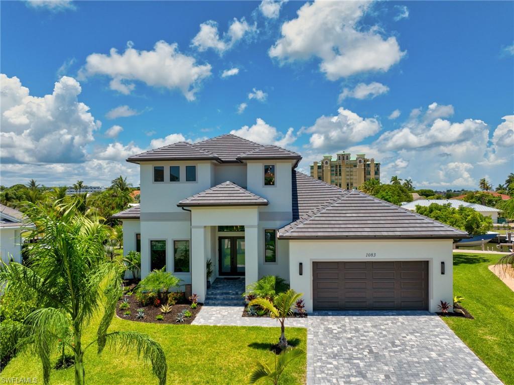 THREE BEDROOMS + A DEN + A LOFT — ALL USABLE AS BEDROOMS. BRAND NEW CONSTRUCTION - 2024.

Cruise from your private dock to the Gulf in just minutes—offering rare, direct boating access with no long idle zones, making spontaneous sunset cruises, world-class fishing, and waterfront dining effortlessly within reach.

Experience elevated waterfront living in this brand-new coastal estate on Marco Island, ideally positioned at the end of a quiet cul-de-sac in historic Old Marco Village. Offering 109 feet of deep-water frontage, a new seawall, and a private dock with a 10,000-pound GEM lift, this residence is designed for boaters, anglers, and those seeking the finest in coastal luxury.

Thoughtfully crafted with timeless architecture and modern sophistication, the home showcases soaring ceilings, expansive impact glass, panoramic canal views, designer wood-plank tile, quartz surfaces, custom lighting, and refined finishes throughout. The chef’s kitchen features premium appliances, custom cabinetry, and generous entertaining space designed for both intimate gatherings and elegant hosting.

The primary suite is a private waterfront sanctuary with a spa-inspired bath, triple shower system, and balcony overlooking the canal. A junior primary suite on the main level offers private pool access—ideal for guests or multigenerational living. The versatile den and loft, both usable as bedrooms, provide exceptional flexibility for family, visitors, or executive work-from-home space.

Outdoor living rivals a private resort, featuring a heated pool with sun shelf, lush tropical landscaping, and a fully equipped outdoor kitchen and bar with seating for six, an AOG grill, Blaze refrigerator, Marvel ice maker, and sink—perfect for effortless entertaining. Professionally designed landscape lighting transforms the estate into a stunning tropical retreat after sunset.

Additional features include CAT5/CAT6 hardwired connectivity, mounted flat-screen TVs throughout, garage mini-split A/C, and included warranties for added peace of mind. Dolphins and manatees are frequent visitors along the canal, completing the rare lifestyle experience this exceptional waterfront property offers.

A sophisticated blend of privacy, luxury, and effortless Gulf access—this is waterfront living at its finest.
