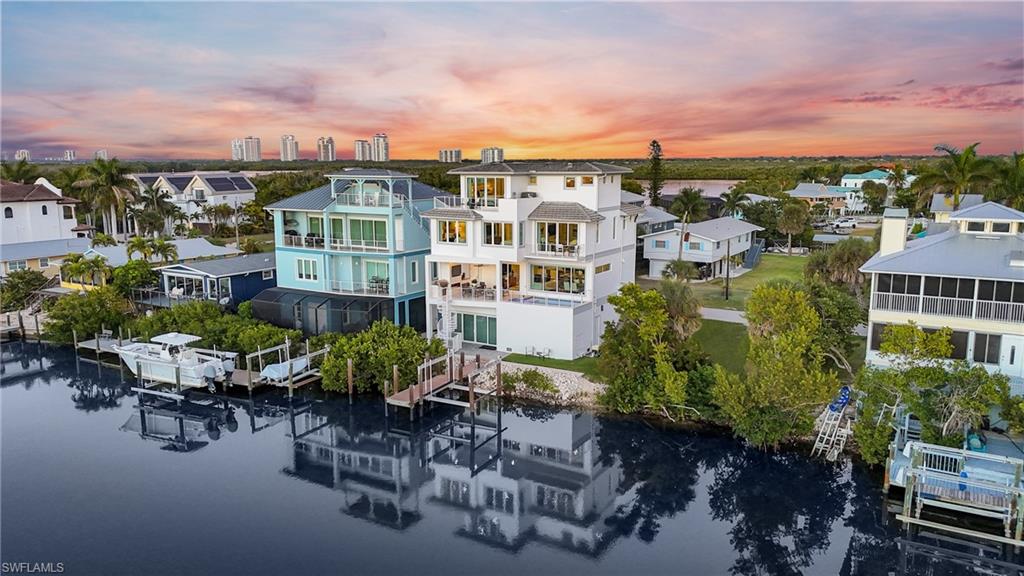 Step into a coastal sanctuary where life slows down, the light feels softer, and every moment feels intentionally crafted. This 2020 concrete block, 15 mins to gulf access, custom-built masterpiece home, offers no HOA. A rare blend of luxury, freedom, and true waterfront living steps from Bonita Beach.
From the moment you arrive, the setting feels different. Sunlight dances across the water. A gentle breeze moves through the palms. The quiet rhythm of the bay creates a sense of calm that stays with you long after you leave.
Inside, warm oak hardwood floors lead you into a bright, open great room designed for gathering, relaxing, and living beautifully. The chef’s kitchen is the heart of the home, complete with Sub-Zero and Wolf appliances, a Sub-Zero tall wine refrigerator, built in U-Line ice maker, Asko dishwasher, Quartzite countertops, a stunning wet bar and island that naturally draws people together. Every detail feels intentional, from the custom cabinetry to the timeless finishes that elevate each space.
The elevated pool and spa on the second level feel like a private resort tucked above the water. The outdoor fireplace, grill, and generous seating area make this lanai a place where evenings stretch long and memories come easily. It’s a peaceful retreat that becomes part of your daily rhythm.
Three balconies offer front row views of dolphins, manatees, and tarpon gliding through the bay and sunsets that paint the sky in unforgettable color. When adventure calls, a spiral staircase leads to your composite dock with a 10,000lb boat lift, where you can step onto your boat and reach the gulf in just minutes. A 250-gallon buried propane tank powers the pool and spa heater, outdoor fireplace, wolf double oven/convection range, two tankless hot water heaters, and outdoor grill for year-round comfort and ease.
With 4 ensuite bedrooms, motorized window treatments, a private elevator to all levels including an entrance to the primary outdoor balcony, impact windows and doors, and an in-home fire sprinkler system, this home delivers both luxury and peace of mind. Wake up to gulf views, walk to Bonita Beach in 2 minutes, or bike to Barefoot Beach and Lovers Key State Park.
Doc’s Beach House, Bonita Beach Access 1, and Coconut Jack’s are just steps away. Mercato, the Promenade, Waterside Shops, Coconut Point, 5th Ave, Gulf Coast Town Center, and RSW Airport are all within easy reach, along with Sanibel, Captiva, and Fort Myers Beach.
This home is more than a place to live. It’s a lifestyle, defined by water, nature, beauty, and the kind of sunsets people dream about. A true coastal masterpiece for the buyer who wants it all.