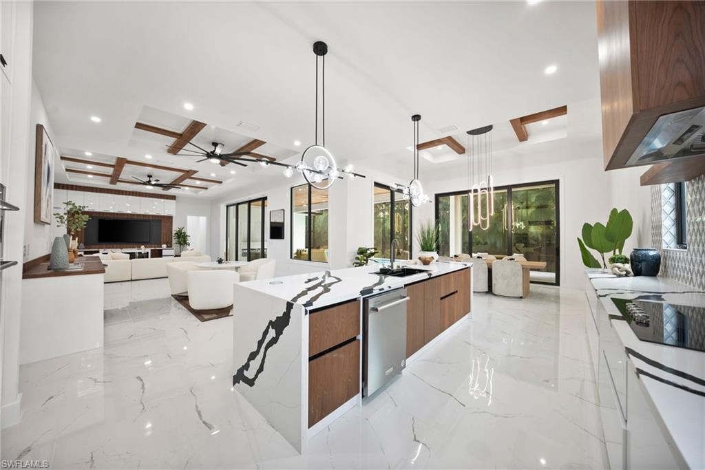 BRAND-NEW 2026-BUILT LUXURY ESTATE, JUST COMPLETED & NOT YET LIVED IN, PERFECTLY LOCATED IN OLDE NAPLES, APPROX HALF A MILE TO WORLD CLASS BEACHES & LESS THAN 1 MILE TO ICONIC 5TH AVE WITH WORLD-CLASS DINING, SHOPPING & ENTERTAINMENT! Enjoy highly coveted Western exposure for breathtaking sunsets, abundant natural light, and optimal sun over the pool. This modern contemporary masterpiece showcases a dramatic open floor plan with 4,730 square feet under air of bright, airy living space, featuring 4 bedrooms, 2 dens (one a loft/multi-purpose “family room”), 5 bathrooms, dual dining areas, dual laundry rooms, a 3-car garage, hurricane impact windows throughout, and a metal roof. Every detail has been thoughtfully curated—from oversized tile flooring and soaring ceilings with wood beam and shiplap accents to the modern wood-and-glass floating staircase and grand two-story entry foyer. The stunning chef’s kitchen is equipped with quartz countertops, sleek white cabinetry, warm wood accents, and an oversized walk-in pantry. Fully pocketing sliding glass doors create a seamless indoor-outdoor living experience. Step outside to your private resort-style oasis, featuring an expansive entertainment deck, large pool and spa, covered lounge area with an outdoor fireplace, and a summer kitchen. The luxurious primary suite is located on the main level and offers direct access to the pool deck, dual walk-in closets, and a spa-like bath with dual vanities, an oversized walk-in shower with dual entries, and a freestanding soaking tub. Upstairs, a loft-style cloud room with wet bar opens to a massive second-floor balcony, providing a private retreat ideal for entertaining or relaxation. Located within an A-rated Collier County school district and just minutes from Venetian Village, Waterside Shops, and Third Street South, this exceptional residence delivers the ultimate in luxury coastal living in one of Naples’ most sought-after neighborhoods.