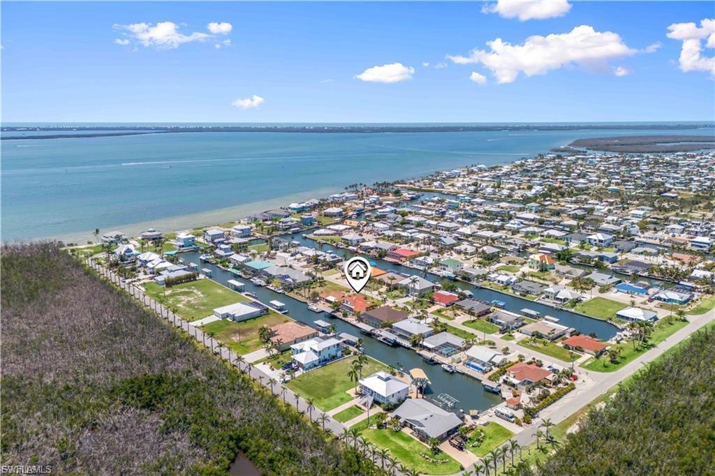 LIVE THE DREAM WITH MINUTES OUT TO OPEN WATERS! Welcome to your dream waterfront home in beautiful St. James City! This fully remodeled 4-bedroom, 4-bath residence offers unparalleled luxury and comfort. Nestled on a direct access canal, a true boater's paradise with a 10,000-pound boat lift, just a few minutes to some of the best fishing, boating and islands in SWFL! As you step inside, you'll be greeted by a massive vaulted ceiling that is light and bright - a modern, open-concept living space with a dream kitchen high-end stainless-steel appliances, sleek ceramic flooring, and stunning quartz countertops. Open to the living area and beautiful views from the window. The layout is thoughtfully designed with two master suites on the ground floor, each boasting en-suite bathrooms, perfect for multi-generational living or hosting guests. Upstairs, you'll find two generously sized bedrooms, one of which opens to a  private balcony, offering serene views of the canal and the surrounding area. Step outside to your personal oasis where a sparkling pool and spa await, ideal for relaxing and entertaining. Whether you're lounging by the pool or enjoying a sunset cruise from your private dock, this home offers the ultimate Florida lifestyle. Don't miss the opportunity to own this exceptional property in St. James City. Schedule your private tour today and experience waterfront living at its finest! All the work has been done, just move right in!