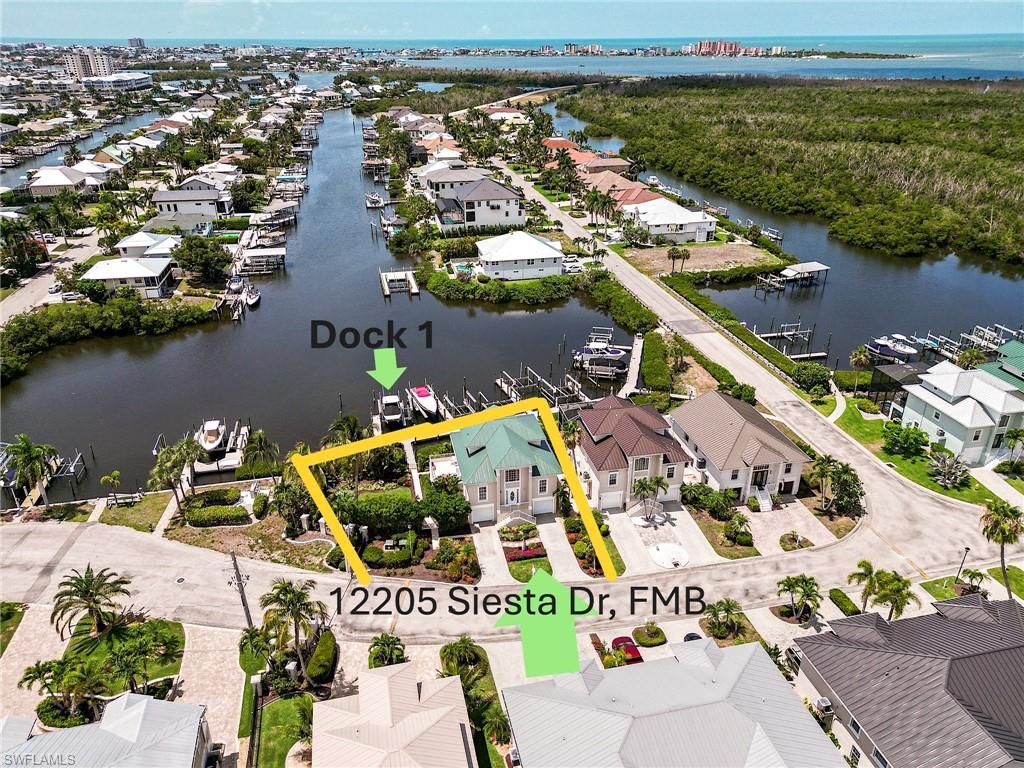 Welcome to 12205 Siesta Drive, the ultimate boating and fishing community located on an oversized southern exposure 1.5-lot parcel in the secure, gated enclave of Old Pelican Bay in Fort Myers Beach, the Boater & Fisherman's Paradise.  With it's  bonus rooms, the home offers over 2300 sq ft of living space under air. This property features one of the deepest, quickest Gulf-access canal locations in Southwest Florida with zero bridge restrictions. Fire up the engines and be in the Gulf in minutes, or head to the Keys and Bahamas. Walk down your private path and step onto your boat. Your private end-unit dock slip features a raised pedestal for dedicated electric and water, easily accommodating a deep-draft yacht up to 48 feet or a heavy-duty lift. Located on the naturally deep East canal, you will never face shallow water or expensive dredging bills. Built to support a marine lifestyle, this oversized 1.5-lot parcel offers plenty of room to add a custom pool and spa, with utility hookups in place. An enclosed, lockable storage shed comes equipped with a dedicated electrical subpanel—perfect for stashing rods, tackle, nets, and diving gear. Tough mechanical upgrades keep maintenance low, including a durable metal roof, private elevator, dual-zone AC, and a central vacuum system. Inside, find refined details including 9-foot ceilings, 3rd-floor cathedral ceilings, crown molding, plantation shutters, and gorgeous, rich maple cabinetry. Over $135k in upgrades and generous credits includes a huge $27,000 cash credit to the buyer at closing. This covers a brand-new appliance package ($6k), new flooring/carpet ($5k), and new 2nd-floor PGT hurricane windows ($16k). Combined with existing 3rd-floor impact glass and motorized storm shutters, the home is built like a fortress. Outside, beautiful Areca palms, Ficus hedges, and a custom 12V landscape lighting system create a magnificent private nighttime oasis. Spend your time on the water, not doing yard work. A weekly landscape crew handles all lawn cutting and edging. Low HOA fees ($429/month) cover your complete lawn care and the community's state-of-the-art security gate, complete with a license plate reader and contractor call-in office.