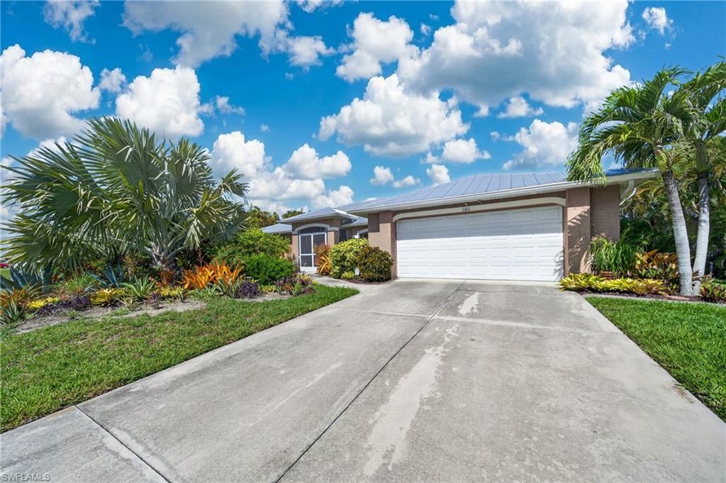 Situated on an oversized THREE-LOT SITE (0.34 acres) in the heart of Cape Coral, this beautifully maintained 3-BEDROOM PLUS DEN, 2-bath pool home offers the perfect combination of space, privacy, and peace of mind. NOT IN FLOOD ZONE, no flood insurance is currently required. Recent major updates include a METAL ROOF (2023) and a SALTWATER POOL featuring a newer pool pump and salt system.

Designed for comfortable Florida living, the home features a bright, open great room with soaring cathedral ceilings and a desirable split-bedroom floor plan. The spacious island kitchen offers a pantry, updated appliances (2021), and opens seamlessly to the main living area, creating an open airy feeling living space.

The spacious primary suite features sliding glass doors leading directly to the screened lanai and pool, along with a custom walk-in closet complete with built-in organizers. Both guest bedrooms include oversized walk-in closets, while the guest bathroom provides direct lanai access, making it an ideal pool bath.

Step outside to your own private tropical retreat. Mature landscaping surrounds the pool and backyard, creating a lush, park-like setting with exceptional privacy. Additional features include city water and sewer, an indoor laundry room with built-in storage cabinets, and a spacious split-bedroom floor plan ideal for both family living and guests.

Conveniently located in the heart of Cape Coral, you’ll enjoy easy access to shopping, restaurants, schools, parks, and everyday conveniences. This move-in-ready home combines quality updates, an outstanding location, and a beautiful outdoor living space that’s ready to enjoy.