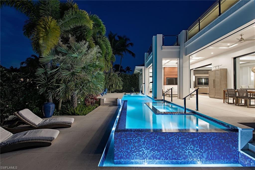 Like new, coastal contemporary home in prestigious Aqualane Shores. Discover luxurious living at this one-of-a-kind, canal front residence complete with dock, resort-style pool/spa, fire pit and putting green! Each of the bedrooms have their own en-suite bathrooms, and the master retreat features a contemporary walk-in shower with multiple shower heads, free-standing soaking tub, dual sinks and vanity area. Modern design and décor can be found throughout the home, showcasing floor to ceiling windows, pocketing sliders, 2nd-floor wet bar and a true chef’s kitchen with top of the line appliances. Entertaining is a breeze with expansive outdoor living which encompasses a full kitchen with a gas grill, bar seating, dining area, and living area with an outdoor fireplace. The Residence is completed with an inviting, infinity-edge pool and spa with canal views. Residence is conveniently located just a short distance from 3rd Street South and minutes from 5th Avenue South’s fine dining, world-class shopping and Naples’ white-sand beaches.