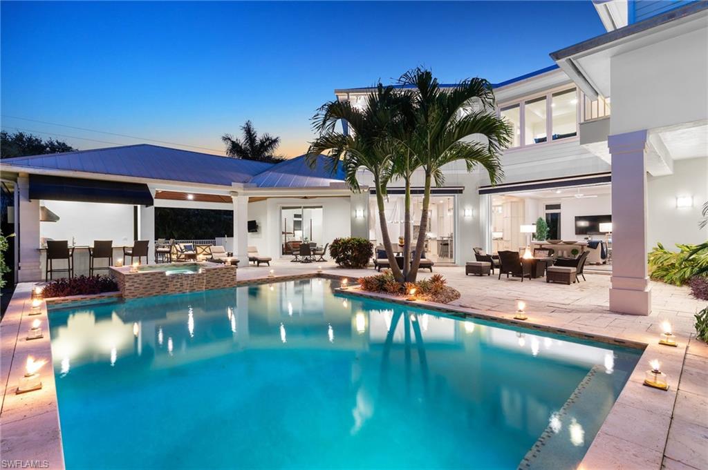 Perfectly positioned in the heart of the Moorings, just moments from Naples’ white-sand beaches, upscale shopping, fine dining, and premier amenities, this exceptional 5-bedroom plus den residence offers the ideal blend of comfort, functionality, and coastal elegance for everyday living and entertaining alike. Spanning over 3,300 square feet on the first floor alone, the thoughtfully designed layout features two split guest suites, a welcoming foyer entry, and an expansive kitchen and family room that effortlessly transition to the outdoor living spaces through dramatic 10-foot pocketing sliders. Designed with a courtyard-inspired concept, the home is centered around the resort-style pool, covered lanai, and summer kitchen—creating a seamless indoor-outdoor experience and an inviting backdrop for gathering with family and friends, with the western exposure enhancing the outdoor living space and providing an abundance of natural sunlight throughout the day. Upstairs, spacious ensuite bedrooms and private balcony spaces provide comfort and privacy for family and guests alike, complemented by the convenience of dual laundry rooms located on both the first and second floors. Timeless coastal architecture, highlighted by HardiePlank siding, a standing seam metal roof, and a three-car garage, completes this beautifully crafted residence designed to complement any lifestyle.