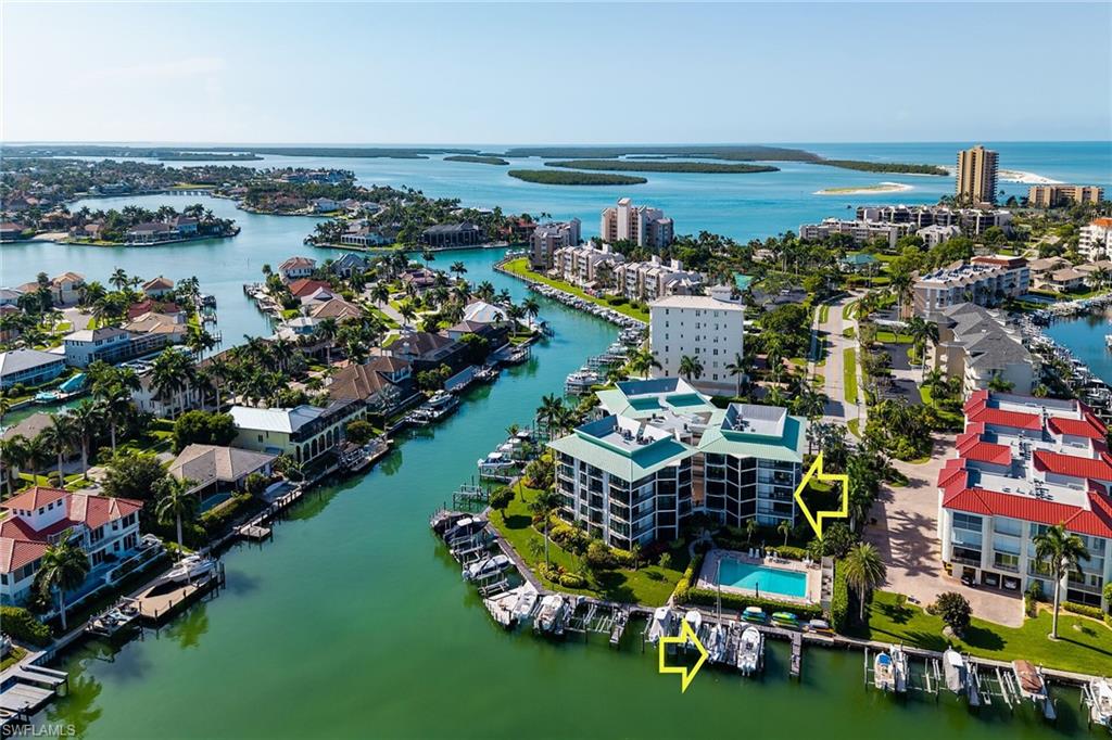 Welcome to your waterfront paradise in Tropical Isle, where exceptional craftsmanship, luxury finishes, and an unbeatable boating lifestyle come together. This beautifully updated residence features a seamless open floor plan designed for relaxed coastal living and effortless entertaining. The stunning kitchen showcases quartzite countertops, impressive custom cabinetry, recessed lighting, and quality finishes throughout. Thoughtful custom built-ins enhance nearly every room, including the living room entertainment center, desk and cabinetry in the breakfast nook, a versatile den with a custom trundle sofa that converts into two beds for additional guests, a rolling storage cabinet, California Closet organizers in the primary suite, solid-core interior doors, and impact-resistant windows and sliding glass doors for comfort and peace of mind. Step onto multiple private balconies and enjoy sweeping waterfront views while watching boats glide by. The porch is enclosed by hurricane sliders, maximizing the living space. Included with the residence is your deeded boat dock featuring a 9,000-pound boat lift, capable of accommodating vessels up to approximately 30 feet overall length, making this a true boater's dream. From your dock, it's just a short idle to open Gulf waters as you cruise past Caxambas Park and into the beautiful waterways of the Ten Thousand Islands and the Gulf of Mexico. Life at Tropical Isle is about more than an exceptional condominium - it's about embracing the Marco Island waterfront lifestyle. Whether you're heading out for a day of fishing, exploring the Ten Thousand Islands, cruising to waterfront restaurants, or simply relaxing while taking in the panoramic water views, this residence offers the complete coastal experience. Schedule your private showing today and discover the exceptional value, boating convenience, and premier waterfront location that make this property truly special.
