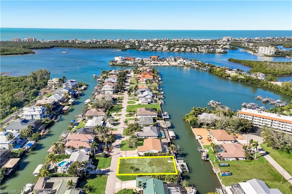 One or more photo(s) has been virtually staged, AI generated or rendered.  BOATERS DREAM Location! GULF Access in minutes. Boat or walk to Bars, Restaurants and Beaches nearby. This exceptional 9,147-square-foot waterfront lot is the perfect place to build your dream home. Situated on a quiet dead-end street, the property features a wraparound dock built in 2015 with a 10,000-pound boat lift, plus a submersible dock with a 7,000-pound lift ideal for kayaks, jet skis, and other watercraft. Imagine your next boating adventure awaits. Just 1.5 miles from the sugar-white sands and breathtaking sunsets of Bonita Beach and Barefoot Beach, this rare waterfront homesite offers the ultimate Southwest Florida lifestyle. With navigable canal access, multiple boat lifts already in place, and a prime location near beaches, dining, shopping, and entertainment, opportunities like this are hard to find. MULTIPLE BUILDER INTRODUCTIONS ARE AVAILABLE.
Location is everything, and this property delivers. Enjoy quick access to waterfront restaurants, grocery stores, fitness centers, and everyday conveniences. Coconut Point is just 7 miles away, while Mercato’s premier dining, shopping, and nightlife are only 6.5 miles from your doorstep. Whether you envision a luxury waterfront estate, a seasonal retreat, or your forever home, this property offers an incredible opportunity to create your own slice of paradise in one of Bonita Springs’ most desirable boating and beach communities.