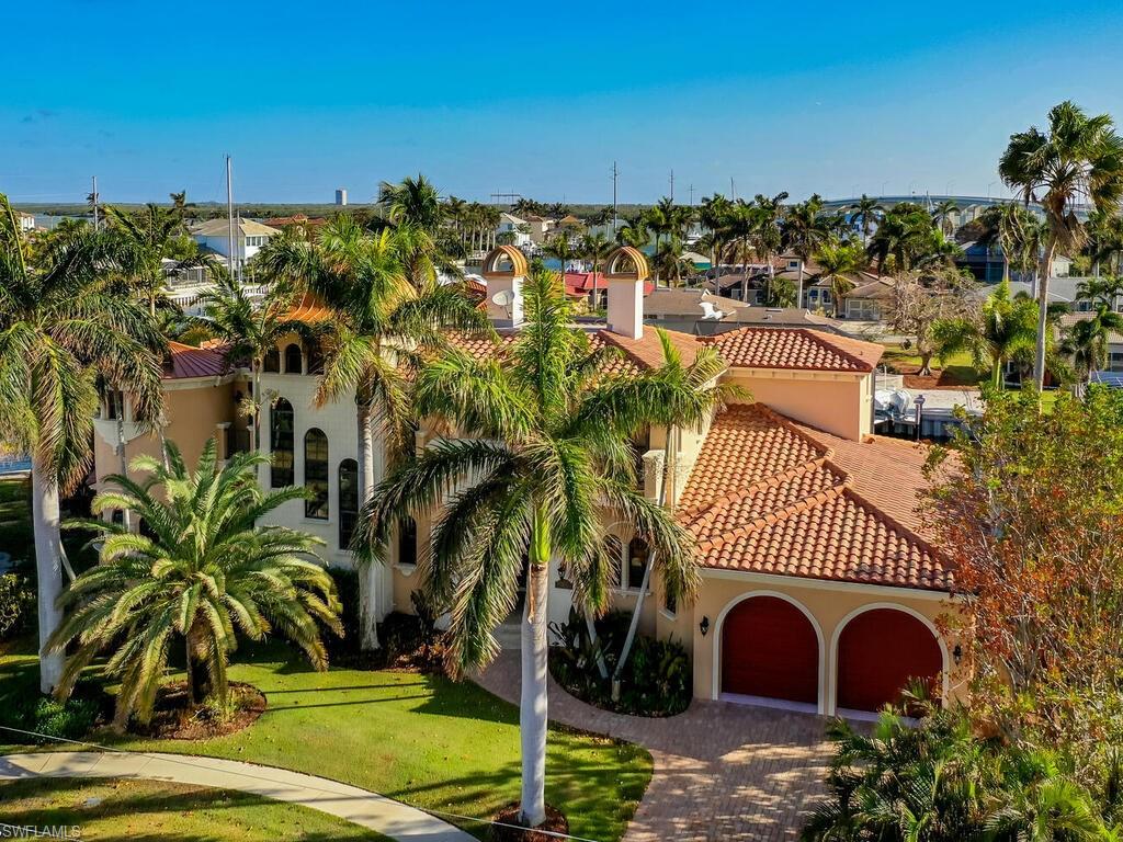 MAGNIFICENT is the only way to describe this large waterfront home. Two stories tall with an elevator and two master suites. Two more bedrooms and four and a half bathrooms make for over 4000 sq ft under air with almost 6000 sq ft of total living space. Custom cabinets with granite countertops, high end ceiling fans, impact windows and doors, upgraded appliances, like an induction cook top! Gas fireplace and heated pool and spa. In ground propane tank is already in place saving thousands in whole home generator installation. New roof 2021, New 2024 oversize pool heater, new Lania screens 2024, newer AC systems. With 153' of waterfront on an intersecting waterway and a 100' wide canal that 65' yacht will easily fit right at your dock and your power boat on the existing boat lift. Just minutes to the Gulf of Mexico with NO BRIDGE for those big sailboats and just a short distance to shopping and restaurants. Being sold partially furnished, this one is a MUST SEE!