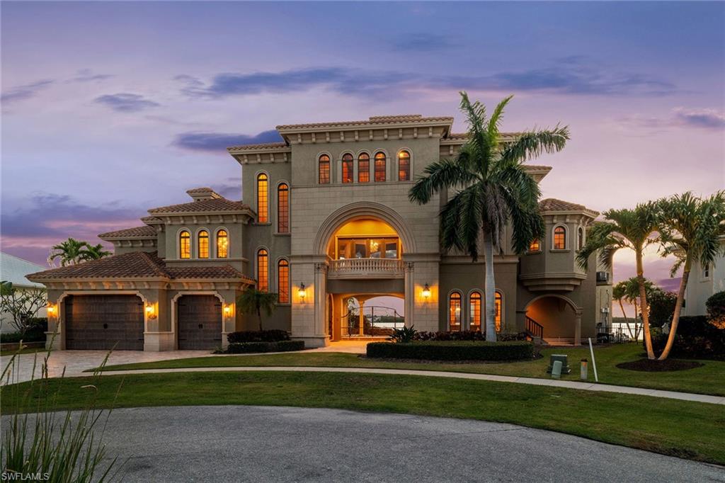 SELLER SAYS SELL! HUGE PRICE REDUCTION! Experience the epitome of Marco Island living in this extraordinary custom-built home, where no detail has been overlooked. With prime western exposure, this three-story residence offers unparalleled views of stunning sunsets over Collier Bay. Encompassing 5,591 square feet of living space, the home is an architectural masterpiece, showcasing exceptional craftsmanship and high-end finishes throughout. Designed with the finest materials, this fully furnished home includes four bedrooms plus a den, four full baths and two half-baths. The gourmet kitchen is a chef's dream, featuring Thermador and Dacor appliances, custom cabinetry, elegant lighting and breathtaking water views. The rich wood tones extend into the cherry-paneled den with Brazilian cherry floors, while the spacious workout room takes full advantage of the open bay vistas. For ultimate relaxation and entertainment, the home offers a billiards room that opens to the pool area, complete with an outdoor fireplace and kitchen, as well as a state-of-the-art eight-seat movie theater with an immersive sound system. The wine room, adorned with hand-crafted designer doors, adds to the home's refined atmosphere. A grand formal dining room with a striking chandelier sets the tone for elegant gatherings. The home's interiors are nothing short of spectacular, with Crema Marfil marble flooring throughout the main areas, including a beautifully curved marble staircase with intricate inlays. Designer hand-carved Bolivian wood doors and custom moldings enhance the home's sophisticated appeal while soaring coffered and tray ceilings create a sense of openness and grandeur. Custom lighting and professional decor further elevate the home’s luxurious ambiance. The expansive primary suite on the main level is a serene retreat with sweeping bay views. It features dual custom vanities, a luxurious Jacuzzi tub, a multi-person shower and two walk-in closets, each with chandeliers. Ideal for entertaining, the outdoor space includes a saltwater pool and spa, a fully equipped kitchen with a gas fireplace, and a boat dock with a 16,000-pound lift, a jet ski dock and lift. A three-car garage provides ample storage and parking. This home is a connoisseur's dream, offering luxury and functionality in a stunning Marco Island setting. It is a rare opportunity to own a piece of paradise where every element has been carefully curated for an unmatched living experience.