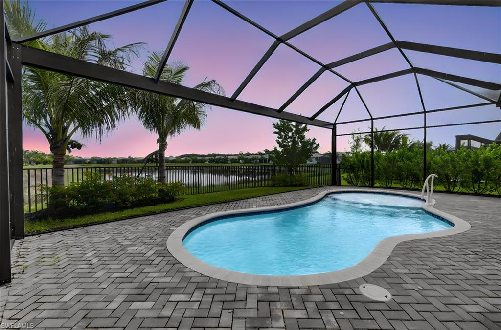 This lusciously landscaped gated and guarded community in Naples, Florida invites you with endless social events and outdoor activities including Tennis, Pickleball, Bocca, Swimming, Fitness classes and specialty clubs. The property conveniently sits in the south side of the community nearby the new Vanderbilt Beach Road access that has recently opened leading to beaches, nearby Mercato with shopping and restaurants. This popular "Pelican" floor plan has 3 spacious bedrooms plus a den and 3 full bathrooms.  The back yard features a screened, inground heated pool, fenced yard and tranquil water view. The covered lani has electric remote controlled hurricane screens. The lot sits on a corner with extra green space for extra privacy and has a Generac whole house generator. Inside features include beautiful light wood flooring in the main living area and bedrooms and tiled bathrooms. The kitchen includes stainless steel appliances with a gas stove, quartz countertops, custom glass cabinets and a pantry closet with pull out shelves. All bedroom closets have custom built-in shelving/drawers, impact windows and doors and plantation shutters throughout. The large laundry room has abundant cabinets and sink. The garage has custom cabinetry and a cooling system. Designer wallpaper and finishes. This home has lots of bells and whistles surely to please so book your appointment today!