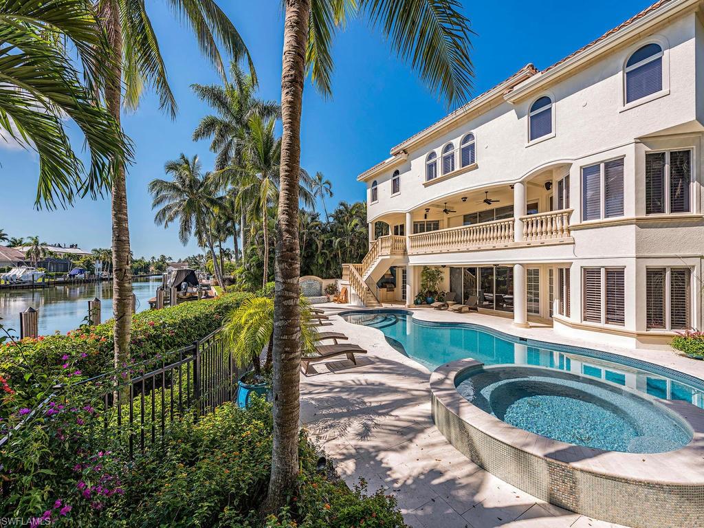 REDUCED $650,000! THE LOWEST PRICED WIDE WATER AQUALANE SHORES HOME FOR SALE AND FEATURING OVER 135' OF WATERFRONT! A spacious 2 story main living room open to the kitchen with the master bedroom and office on the main level. Upstairs or by elevator, there are 3 bedrooms and an open sitting area.  Ideally situated on an oversized deep water home site and within walking distance to the sugar sand beaches of Olde Naples and 3rd St fine shopping and dining. 215 feet on the North side of property provide an a very rare extra driveway/yard and easy access to the docks for the boating enthusiast.  The small dock/lift extending into the canal is grandfathered from the original owner and rarely found in Aqualane Shores providing room for multiple boats.  The pool level of the home features an additional 1400 sq ft of air conditioned entertaining area off the newly renovated pool and spa area. The home features stone flooring, stone countertops, gourmet kitchen, impact windows, new interior paint, elevator, outdoor kitchen, oversized garages, and front and rear 2nd floor patios. A tremendous value and rare offering for the wide water streets within Aqualane Shores.