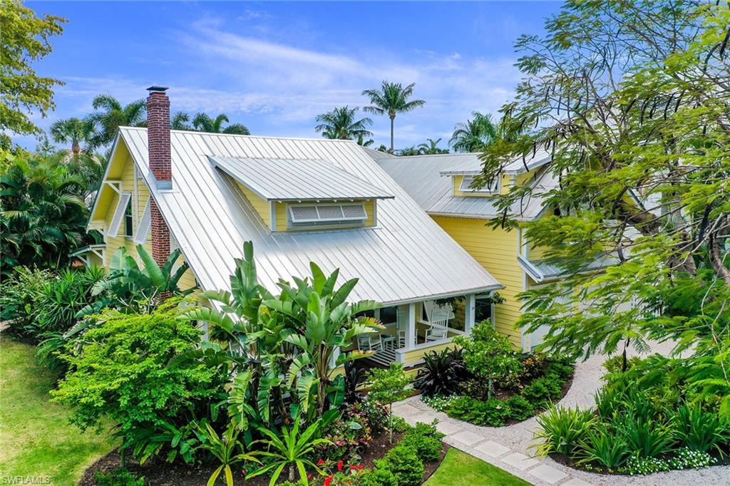 The historic 1929 Captain Parker House is not just amazing because of the finishes, the architecture, or that it was the first house built on 8th Ave S, but also because it captures the dream of Old Naples. The botanical garden setting overlooking Cambier Park is on a private corner with a 50' Royal Poinciana tree planted in 1939, birds of paradise, frangipani, banana, coffee, coconut and gardenias. The 2-story home has the original look, feel, warmth and character of a historic home including restored old-growth heart pine floors, metal roof and large porch. Combined with all the modern updates including a chef’s kitchen with a Lacanche gas range, Sub-Zero refrigerator and wine cooler, new bathrooms, high ceilings, whole-house generator, impact-rated windows and Hardie board siding. Enjoy the private grotto-style pool hidden a world away behind lush tropical landscaping. All within a short distance to 5th Avenue South, Third Street South and Naples' famous beaches. If life in a tropical paradise location with charming palm-lined streets, chic boutiques, restaurants, and white sand beaches is your Naples dream, make this sunny playground your home.