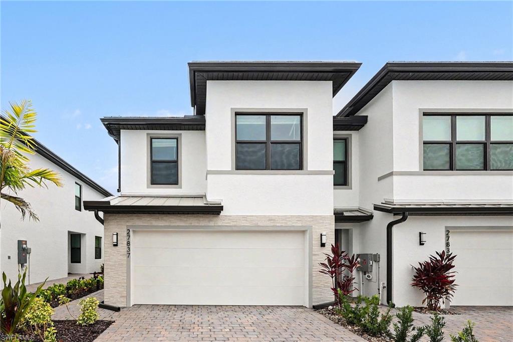 End-unit townhome with OVER $24,500 IN BUILDER UPGRADES. Custom enhancements include a designer wood slat feature wall, peaceful preserve views, and a spacious two-car garage. The bright, open-concept floor plan is designed for effortless living and entertaining, featuring PEARL JASMINE QUARTZ COUNTERTOPS, an OVERSIZED ISLAND, white SOFT-CLOSE cabinetry, Whirlpool STAINLESS STEEL appliances, a designer LANTERN MOSAIC BACKSPLASH, and CERAMIC WOOD-LOOK TILE FLOORING throughout the main level.

Upstairs, the owner's suite offers dual vanities, a WALK-IN SHOWER, and a CUSTOM WALK-IN CLOSET, while two additional bedrooms also feature custom closet systems. Additional upgrades include LED lighting, upgraded shelving, PENDANT LIGHT PREWIRE, TV prewire, DUAL MEDIA CONNECTIONS, and premium hardware throughout.

Additional features include IMPACT-RESISTANT WINDOWS, a TILE ROOF, an EPOXY-FINISHED GARAGE FLOOR, and a COVERED LANAI that extends your living space outdoors while overlooking a tranquil preserve, offering privacy rarely found in townhome living. With Smart Home technology and quality finishes throughout, this home offers the peace of mind and low-maintenance lifestyle today's buyers are looking for. Enjoy low HOA fees, no CDD, and an exceptional location just across from Midtown at Bonita Springs, with convenient access to shopping, dining, I-75, Southwest Florida International Airport, and the Gulf beaches.