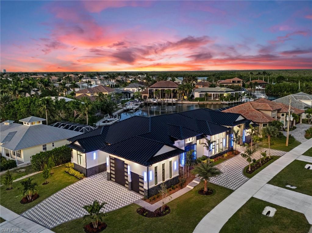 A Waterfront Masterpiece of Modern Island Living!
Bold, fresh, and beautifully refined, this newly built luxury residence on Marco Island is the ultimate expression of coastal sophistication. Crafted for those who crave space, comfort, and effortless indoor–outdoor living, this home blends high-end design with everyday practicality in the most irresistible way. 
Step through the front doors and feel the scale instantly—towering ceilings, gallery-style hallways, and stone finishes that shimmer in the natural light. The 32-foot great room unfolds like a private resort, giving you big water views across the pool, space to entertain on a grand scale, and zones to relax, dine, gather, or simply breathe. 
Five ensuite bedrooms ensure everyone has their own sanctuary, while the additional den gives you the freedom to create a media lounge, work-from home base, or creative studio. The primary suite is a world of its own—your quiet hideaway with a spa-style bathroom and a huge walk-in dressing retreat designed to elevate everyday living. 
Just beyond the living areas, the outdoor domain feels like a tropical escape. The sparkling pool, cascading spa, and sun shelf with “tropical wade-in” vibes invite you to unwind any time of day. And because the home is elevated above flood level without a single entry step, you get peace of mind and the convenience of true single-level living. 
Right at the heart of the home is a chef’s kitchen built for serious cooking and easy hosting. Think high-end appliances, abundant cabinetry, an entertainer’s island, and a separate butler’s pantry that keeps prep tucked neatly out of sight. The oversized laundry room, powder bath, and dedicated pool bath make daily living smoother, cleaner, and so much more comfortable.
The 1,700 sq ft garage is engineered for NINE cars or a full motor coach. Smart-home tech and impact-rated windows provide security and control.  Energy-efficient super-insulation offers better comfort and reduced costs.
Set on an oversized direct-access waterfront lot, this address launches you straight into the open river making boating, fishing and sunset cruising incredibly easy. Shops, dining, beaches, and everyday essentials are just minutes away, and the island offers leafy parks, walking trails, and that relaxed Marco Island coastal atmosphere that makes every day feel like a holiday.