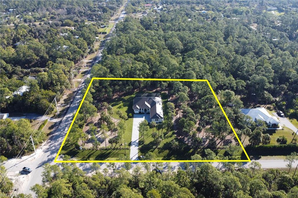 A rare opportunity to secure a standout new construction before it’s gone—offering hard-to-find features and exceptional quality that truly separate this home from many new builds in the area. Featuring 4+Den, 5 full baths, a metal roof, 3-car garage, extended paver driveway, whole-house reverse osmosis system, and no HOA. Situated on 2.73 ACRES of 100% UPLAND on a desirable corner lot, the property offers entrance through 19th St SW and the advantage of adding a second driveway. Whether you envision a workshop, guest house, additional structure, or simply need space to park trucks and toys, this property delivers the freedom to create the lifestyle you’ve always dreamed of. Inside, neutral finishes and tones set the stage for a modern yet timeless design, enhanced by wood-look porcelain tile throughout, hardwood ceiling accents, and a custom living room TV wall with a sleek, aesthetic fireplace. The kitchen is a true showpiece, featuring abundant custom cabinetry, generous storage, quartz countertops, double ovens, stainless steel appliances, and a wet bar with wine fridge. Every bedroom is designed as a private suite, each offering its own walk-in closet and en-suite bathroom—a rare and highly desirable feature that elevates both comfort and functionality. Step outside to a spacious outdoor living area featuring a heated saltwater pool, shell stone paver deck, and a built-in grill summer kitchen, all within a fully screened lanai—ideal for relaxing, hosting, and enjoying Florida living year-round.