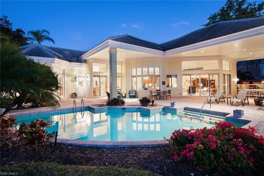 Absolutely the most beautiful setting you will see in Pelican Bay. Sweeping views of the lake and the second hole of the Bay Course. 0.51 acres. This home was built in 1992 with foresight: the ceilings are 12 to 14 feet high in the main living areas, 9-foot ceilings in the bedrooms, open floor plan, three bedrooms, a den and four full baths in the main home plus two bedrooms, a kitchen and full bath in the guesthouse, three-car garage. Sit by the pool or on the covered veranda overlooking the lake and watch the beautiful sunsets. Light and bright house. The kitchen features a gas cooktop, stainless steel appliances and green granite countertops and a walk-in pantry. Sunken bar in the family room with sink and refrigerator. Two new AC units in 2020 and the third in 2022. Enjoy all that Pelican Bay has to offer: almost three miles of private beach, two beach restaurants (destroyed by Hurricane Ian and being rebuilt). Two tennis centers, a state-of-the-art fitness center, bike and walking paths, kayaks and canoes.