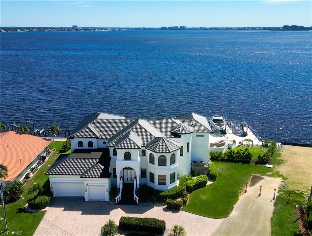 Prestigious 2-story home with 170FT of seawall located on the Caloosahachee river. Step inside and be greeted by the exquisite craftsmanship and high-end finishes throughout, including marble flooring and contemporary decor. The gourmet kitchen was completely updated in 2022, featuring built in appliances, and elegant quartz countertops. The first floor of the 5050 SFT home offers a huge living room, separate family room, a formal dining area, master bedroom and a work-out room; 3 more master suites and a DEN are located on the second floor, which can be accessed by two staircases. The main master suite features a sitting area, as well as a balcony. Every room provides breathtaking water views. Step outside to an oasis of relaxation: oversized saltwater pool with infinity edge, jacuzzi, 2 new electric heaters and a large travertine pool deck providing many different lounging areas as well as a huge covered lanai. This home is equipped with a range of desirable features, such as hurricane impact doors and windows, additional electric shutters for shade and protection for your patio furniture, a new metal roof (2023) and a new boat dock with 20k lb boat lift and 7k lb jetski lift (2023) both with captains walks. The 3 -car garage, two laundry rooms and 7 AC units/ zones provide convenience and functionality. Don't miss the opportunity to own this exceptional property that offers both luxury and privacy and comes fully furnished and decorated.
