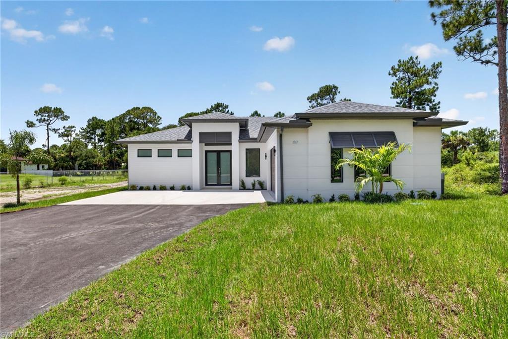 Stunning 3 Bedroom plus Den, 2 & 1/2 Bathrooms, 2 Car Garage Residence on a 2.34 Acre lot at Golden Gate Estates! This gorgeous home boasts with high quality finishes such as high ceilings, and a kitchen featuring custom wood cabinets, quality stainless steel appliances including a glass cooktop, hood over range and wall oven. The wood-like plank porcelain tile throughout the home adds warmth; and impact resistant doors and windows peace of mind during hurricane season. The owners suite showcases a luxurious master bathroom with freestanding tub, spacious shower and a dual sink. In addition, a beautiful outdoor area with a spacious patio showcasing custom cabinets, a built in grill and plenty of space for a pool and much more.