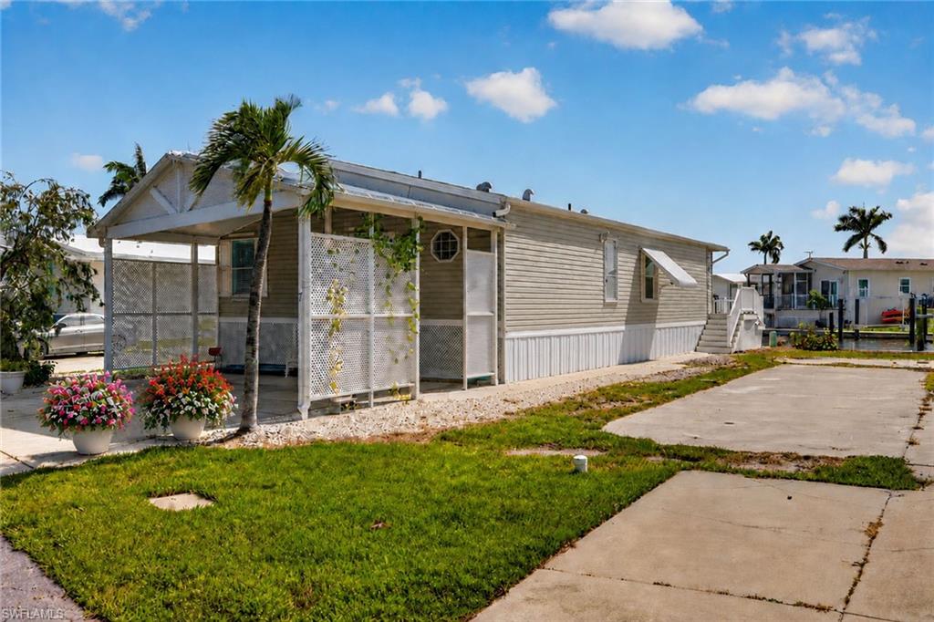 Welcome to Port Carlos Cove, one of Fort Myers Beach's most sought-after waterfront 55+ communities, where Gulf-access boating, an active lifestyle and exceptional value come together. This Skyline-built manufactured home, constructed in 2000, offers 1,361 square feet of living space with a spacious two-bedroom, two-bath floor plan and a desirable canal-front location providing direct boating access to Gulf. Built by Skyline Homes, one of the nation's most recognized manufactured home builders, this residence benefits from the reputation of a well-established manufacturer while offering buyers an opportunity to enjoy waterfront living at a fraction of the cost of many traditional waterfront homes in Southwest Florida. Designed for comfortable Florida living, the home features vaulted ceilings in the main living area, abundant natural light, luxury vinyl plank flooring, updated wood cabinetry and a generously sized primary suite. Abundant windows and architectural ceiling details create a bright and inviting atmosphere throughout the home. Outside, enjoy the waterfront setting from the composite rear deck overlooking the canal. Boaters will appreciate the easy access to some of Southwest Florida's most popular boating destinations. Whether you enjoy fishing, cruising, waterfront dining or exploring the islands by boat, this location places it all within reach. Improvements include an elevated 2023 air-conditioning system, hurricane shutters and updated interior finishes. For peace of mind, the home has an affordable transferable flood insurance policy. The improvements to this home have addressed many of the major updates and there remains an opportunity for the next owner to add their finishing touches to make this space their own. Port Carlos Cove offers an active and social lifestyle with amenities that include a community pool, clubhouse, pickleball courts, boat ramp and golf cart-friendly streets. On-site storage for boats, boat trailers, RVs and recreational vehicles, a rare convenience, is also included within the community amenities. Ideally just minutes from Fort Myers Beach, waterfront restaurants, marinas, shopping and entertainment, this property presents an exceptional opportunity to enjoy the boating and beach lifestyle that makes Southwest Florida a popular destination. Rarely does a Gulf-access waterfront opportunity on Fort Myers Beach become available at this price point. Schedule your private showing today and discover the value and lifestyle this unique waterfront property has to offer. One or more photo(s) has been virtually staged, AI generated or rendered.