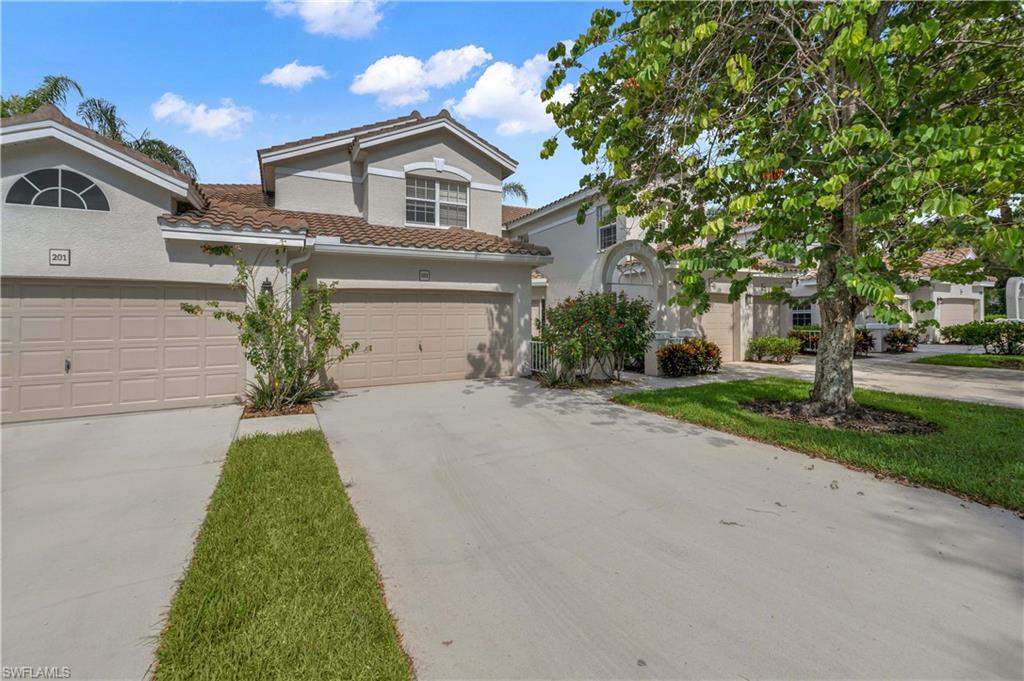 One or more photo(s) has been virtually staged, AI generated or rendered.  Experience the ultimate resort lifestyle in this completely renovated and meticulously maintained lakefront coach home. Situated on a quiet interior street within the gated community of Calusa Bay, this desirable first-floor end residence offers an expansive light-filled floor plan with elegant tile flooring. The chef's kitchen features natural quartz stone countertops with a breakfast bar and stainless-steel appliances, flowing seamlessly into the dining area and great room. Relax in the spacious primary suite with dual walk-in closets and a spa-like en-suite bath with a walk-in shower, freestanding tub, and dual vanities. Enjoy two additional bedrooms, a full bath, and additional large hall closet or pantry. Outside, enjoy serene sweeping lake views through sliding glass doors to a screened lanai with electric storm shutters. Other upgrades include solid interior shaker doors, new hardware, and plantation shutters throughout. This is one of the few residences in the community featuring an attached two-car garage. Calusa Bay is minutes from the Gulf and premier shopping and dining. Amenities include two pools, spa, fitness center, Har-tru tennis courts, walking paths, a clubhouse, and on-site management with an active social calendar.
