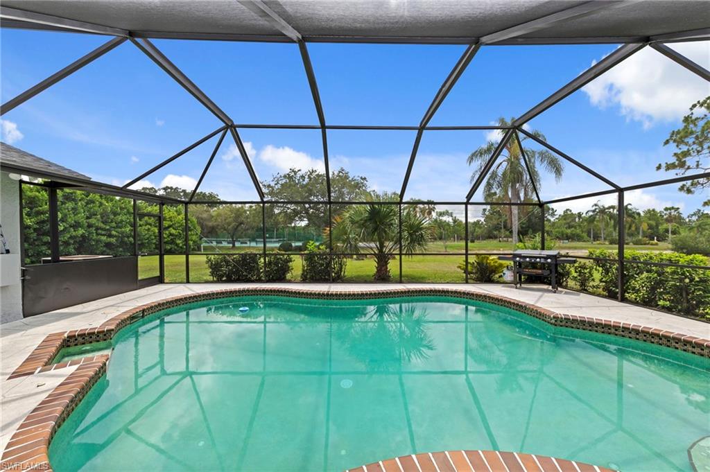 Set within the private, gated community of Kings Bay Estates on the bank of the Caloosahatchee River, this property sits on nearly half an acre of land, offering something increasingly uncommon in Southwest Florida. With just 50 home sites, the community maintains a quiet, uncrowded character that larger developments simply cannot replicate. Inside, the home offers over 2,400 square feet of living space beneath soaring vaulted ceilings, with modern tile flooring throughout. The layout begins with a formal living and dining room at entry, then flows into a well-configured kitchen with Copacabana granite countertops, a large center island, wall oven, stainless steel appliances, and a pass-through window to the lanai that keeps indoor and outdoor entertaining connected. A separate eat-in kitchen area and wet bar add practical flexibility for everyday living and hosting alike. The family room centers on a real built-in wood-burning fireplace, a genuine architectural feature that adds warmth and character to the space. The roof was replaced in December 2021, the septic tank and drain field were replaced in 2022, and the A/C unit was replaced in 2024, giving the next owner a solid foundation of recent updates. The primary suite is generously proportioned with French doors that open directly to the screened lanai, and the ensuite bath includes a tiled shower and dual vanities. Additional bedrooms provide comfortable accommodations for family or guests. The freeform pool anchors the outdoor living space, surrounded by stamped concrete and enclosed within an expansive screened lanai with western rear exposure. Afternoons here shift from full sun to shade as the day winds down, and the open sky to the west means unobstructed sunset views directly from the pool deck. The scale of the lanai itself is worth noting, as there is genuine room for both a full outdoor dining setup and lounge seating without the space feeling crowded. The property also includes a fruit-bearing mango tree on the grounds and the existing flood policy is transferable to the new owner. Kings Bay Estates carries low annual HOA dues and a gated entry. I-75 is easily accessible, connecting residents to Fort Myers, Cape Coral, Naples, and the broader Southwest Florida area. Route 31 provides direct access to Babcock Ranch and the growing communities along that corridor. Everyday conveniences, dining, and shopping are all within a short drive.