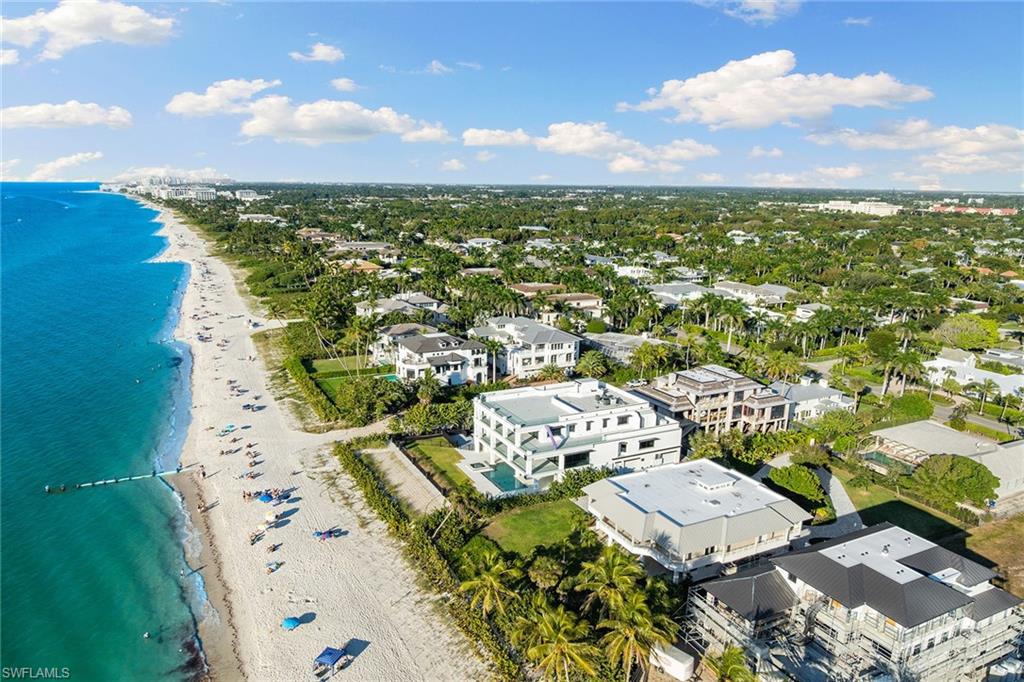 Incomparable Gulf and sunset views set a new standard for coastal living in this extremely rare, new, beachfront estate in Old Naples. Completed in 2025 on an expansive lot with 120 feet of frontage, this architecturally significant estate built by D. Garrett Construction offers a unique opportunity to own an estate of this scale, design and quality without enduring a several-year construction timeline. Decorator-ready interiors provide an exceptional canvas for personalization. Concrete construction on all levels and a private elevator servicing every floor, including the massive 5,000-plus-square-foot rooftop deck with 180-degree panoramic beach views, an extremely rare amenity, provides a one-of-a-kind beachfront experience. Two covered Gulf-front terraces, pool and spa, outdoor shower, fully fenced grounds, whole-house water filtration, generator, electric screens and shutters, and garage parking for six or more vehicles complete this unmatched offering, just three blocks from iconic Fifth Avenue South.