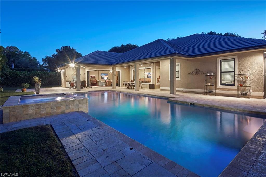 Set on one of the most coveted, highly elevated banyan-lined streets in The Moorings, this exceptional four-bedroom plus den residence offers refined coastal living designed for both grand entertaining and everyday comfort. Encompassing over 3,800 square feet, the open-concept great room floor plan is highlighted by soaring vaulted ceilings and an expansive dining area, all framed by tranquil views of the lush, private backyard.  Seamlessly extending the living space, the fourth bedroom has been thoughtfully reimagined as a sophisticated family lounge, complete with a wet bar and full bath. Dramatic 90-degree pocketing sliders open to a generous covered lanai, creating a flawless transition between refined indoor comfort and relaxed outdoor living. The secluded outdoor retreat is anchored by an oversized heated pool and elevated spa, complemented by a fully equipped outdoor kitchen, making it ideal for year-round enjoyment in Naples’ renowned mild winter climate.  Thoughtfully appointed, the home includes impact-rated windows and doors throughout, two dishwashers, a Generac whole-home generator, 750 gallon propane tank, an oversized attached two-car garage all on a beautifully landscaped .37-acre homesite. Perfectly positioned, this premier Moorings location is just a short stroll to popular restaurants and Publix, while residents enjoy exclusive access to the private Moorings Beach Park.  A rare opportunity to experience the ultimate in luxury, lifestyle, and location in one of Naples’ most desirable neighborhoods.