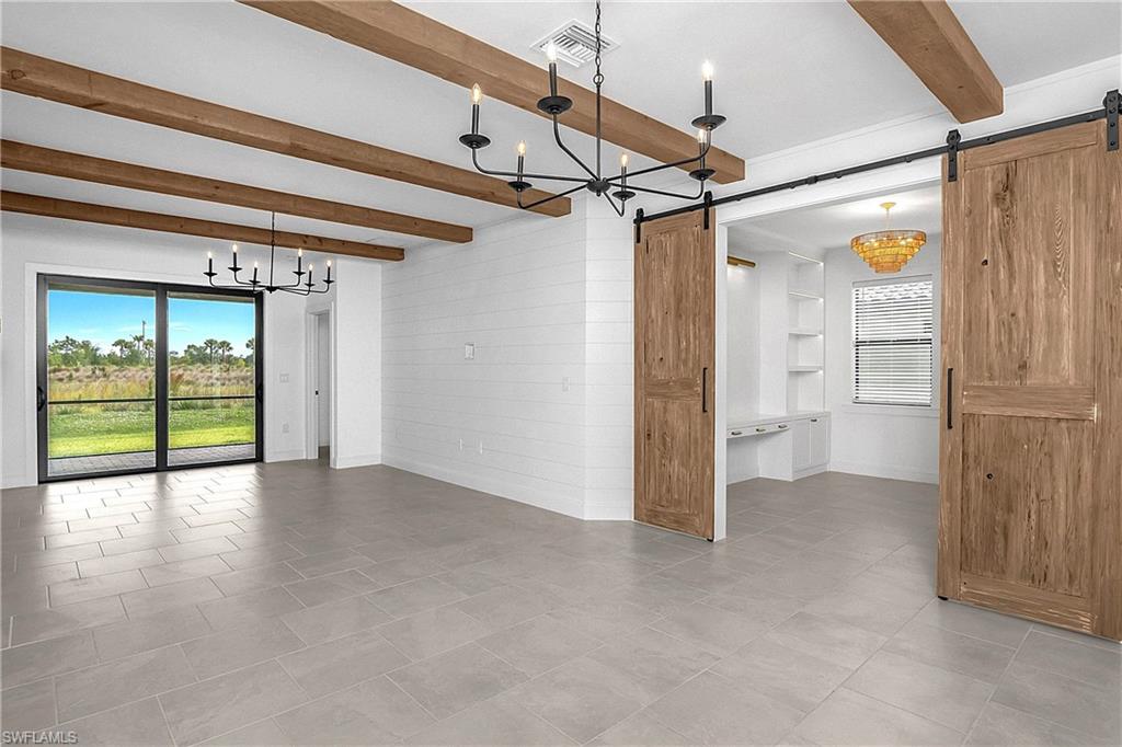 THIS HIGHLY UPGRADED ATTACHED VILLA IN VERDANA VILLAGE IS A DESIGNER'S DREAM COME TRUE! NATURAL WOOD BEAMS, BARN DOORS, CUSTOM BUILT-INS, SHIPLAP ACCENT WALLS, DESIGNER LIGHTING, AND THAT'S JUST THE BEGINNING!! Offering 3 Bedrooms (one setup as a Den), 2 Full Baths, 2 Car Garage, and 1,417sf living area, this beautifully appointed residence showcases a level of craftsmanship and attention to detail rarely found in a villa. From the moment you step inside, you'll be welcomed by DESIGNER FINISHES, CUSTOM WOOD ACCENTS and thoughtfully curated spaces that create a warm and inviting atmosphere throughout. One guest bedroom features SLIDING BARN DOORS and is staged as a Den with CUSTOM SHIPLAP OFFICE-STYLE BUILD-OUT complete with LINEAR DOWNLIGHTING and a CUSTOM BUILT-IN CLOSET, creating the perfect home office, flex space or guest overflow area. TILE FLOORING flows throughout the entire residence (NO CARPET ANYWHERE!) and is complemented by HIGH-END DESIGNER LIGHT FIXTURES that tie every room together. The Kitchen boasts WHITE CABINETRY, QUARTZ COUNTERTOPS, STAINLESS STEEL APPLIANCES with a NATURAL GAS RANGE and an OVERSIZED INTEGRATED BAR providing ample space for seating, serving and entertaining. The Great Room is highlighted by NATURAL WOOD BEAMS accentuating the ceiling and a CUSTOM SHIPLAP FEATURE WALL, creating the perfect SOUTHWEST FLORIDA gathering space for family and friends. The Primary Suite is privately tucked away at the rear of the home, offering SCENIC FLORIDA VIEWS and a peaceful retreat at the end of the day and is joined by a SPACIOUS WALK IN CLOSET. The Primary Bathroom provides generous space and functionality with White Cabinetry with QUARTZ COUNTERTOPS, DUAL SINKS and an ENCLOSED SHOWER. The Second Guest Bedroom spares no expense with a CUSTOM BUILT-IN WHITE WOOD BUNK BED SYSTEM (can be removed prior to closing if desired), SHIPLAP ACCENT WALL and CUSTOM CLOSET ORGANIZER, making it both stylish and practical for family and guests alike. Step outside to the NORTH-FACING SCREENED LANAI where you'll enjoy comfortable YEAR-ROUND OUTDOOR LIVING without the harsh afternoon sun. Whether entertaining guests or simply unwinding after a long day, this spacious outdoor area provides the perfect setting to relax and enjoy the Florida lifestyle. THIS BEAUTIFULLY DESIGNED VILLA IS TRULY ONE-OF-A-KIND AND OFFERS A LEVEL OF CUSTOMIZATION RARELY AVAILABLE IN VERDANA VILLAGE!! Amenities include Indoor/Outdoor Pickleball & Tennis, Indoor basketball, Bocce, Clubhouse, Dog Park, Resort-style Pool& Spa, Fitness center, Movement Studio, Playground, Restaurant, Craft Beer lounge, Cafe and Indoor/Outdoor bar. Satellite amenity to come which includes Social Room, Pool/lap lanes, Fitness Center, Sports Field. Publix Plaza located just outside community gates!