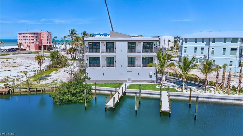 One or more photo(s) has been virtually staged, AI generated or rendered.  Live where your boat, beach days, and brand new luxury all come together - featuring direct Gulf access boat slip, private enclosed garage, prime North end location & only 400 ft to the beach. 855 Lagoon Street offers high-performance SIP construction, hurricane-ready engineering, a new bulkhead, and low-maintenance tropical landscaping. Inside, enjoy a bright open floor plan, elegant tilework, modern cabinetry, generous bedrooms, and timeless finishes throughout. Enjoy a privilege few condos offer: YOUR OWN PRIVATE BOAT SLIP with direct Gulf access. Your designated boat slip is just steps from the door—reach the Gulf in about 10 minutes. A rare enclosed garage with epoxy floor provides secure parking and storage for a vehicle, golf cart, or water toys. Community amenities include a beautiful pool and professionally maintained grounds. Unbeatable walkability to Margaritaville, Times Square, Bowditch Park, dining, shops, and the new Whale. Quick on/off island access adds daily convenience and strong future value. From peaceful mornings on the water to vibrant evenings just steps from the island’s best dining and entertainment, 855 Lagoon Street offers the full rhythm of Fort Myers Beach living — elevated, effortless, and ready now. If you’ve been waiting for the rare new-construction waterfront condo that checks every box, this is it. Your future island lifestyle begins here. A best-in-class North End opportunity.