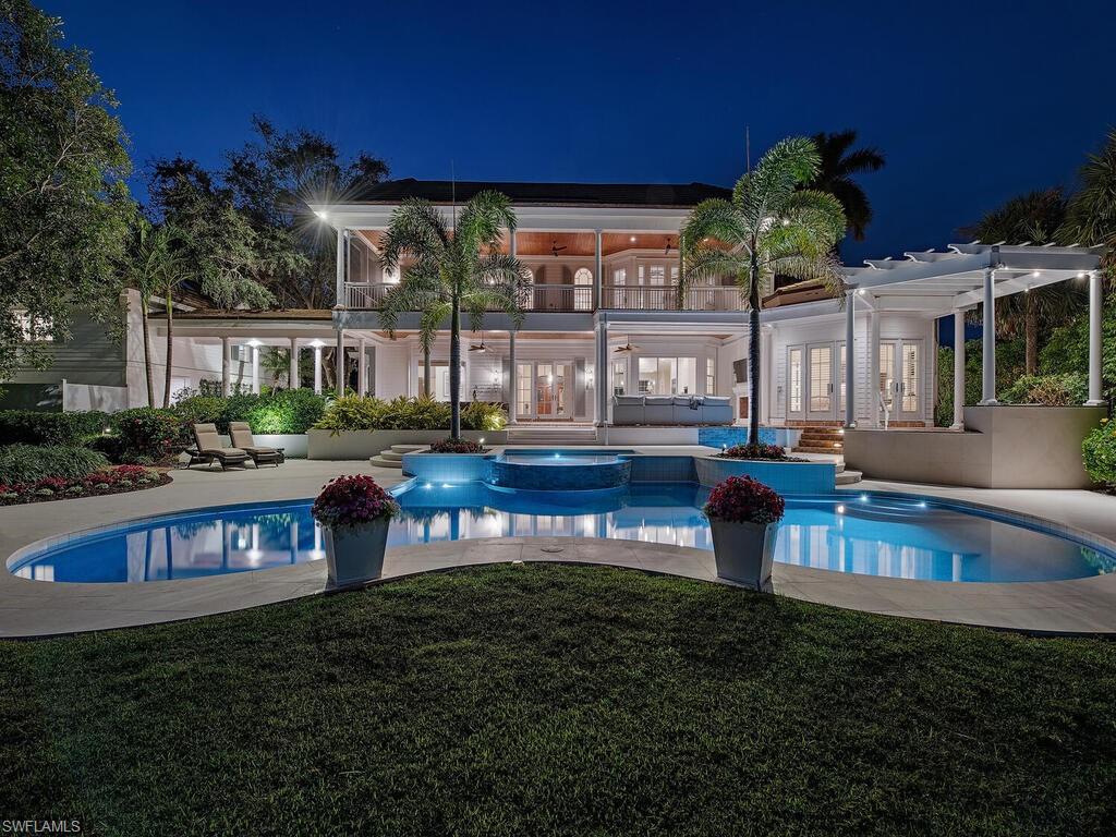This Port Royal southern classic coastal retreat is a masterstroke collaboration by architects David Humphrey, Jon
Kukk, Matt Joyner, and constructed by Frontier Custom Homes. In an ideal position walking distance to the 
Port Royal Club and the 3rd Street South entertainment district, this furnished home also
offers a 2 bed, 2 bath guesthouse. Situated on a generous lot and a half, the distinguished estate features an
expansive wraparound porch and an astounding 3,000 square feet of covered outdoor lanais for relaxation and
entertaining. With one-of-a-kind reclaimed century-old Chicago brick underfoot, the space opens to serene views
of Lantern Lake’s glistening waters, framed by gently swaying palms transforming the backyard into an oasis.
Attentively maintained with thorough upgrades, the gourmet kitchen features one-inch-thick cabinetry by Ruffino,
appliances by Wolf, Sub-Zero, and Viking, two wine refrigerators and bar. The primary suites have been
modernized exquisitely. Custom onsite millwork, solid American cherry wood flooring and front door highlight the
refinement of this elegant residence. A newer pool with striking shell stone decking sets off the stunning backyard
area. This remarkable property offers a new 32kw generator. Club membership eligible.