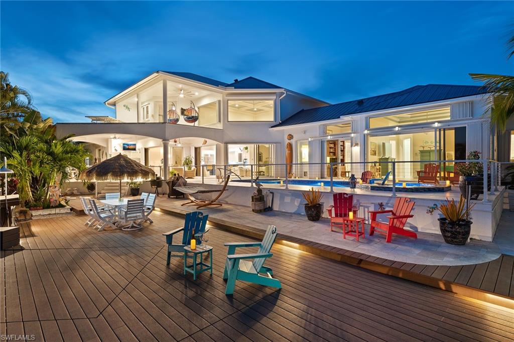 You can truly have it all in your updated, southern-exposure, direct boating access waterfront home with 5 bedrooms plus study, 5 baths, 3-car garage and long water views. This luxurious home lives like its own resort with an amazing outdoor living space with new travertine, refurbished saltwater pool and spa with colored party lights and new pool heater, pool bath, brand-new huge deck overlooking the water, fish lights and 2 platform boat lifts - 7,500 LB and 14,000 LB. New roof in 2019, new seawall and dock in 2021, new paint in 2019. When you enter through the dramatic double doors, you will immediately be impressed with the view of the pool and water, volume ceilings, expansive windows, open floor plan and plentiful natural light. Extensive features include plantation shutters, central vac and crown molding. Kitchen was remodeled in 2021 with quartz counters, stainless, double oven, cooktop and walk-in pantry. The spacious master suite offers access to the pool, dual vanities, walk-in shower and tub. Excellent layout with 2 guest rooms downstairs and 2 guest suites upstairs. Beautiful neighborhood convenient to the beach and everything that we love about the island lifestyle.