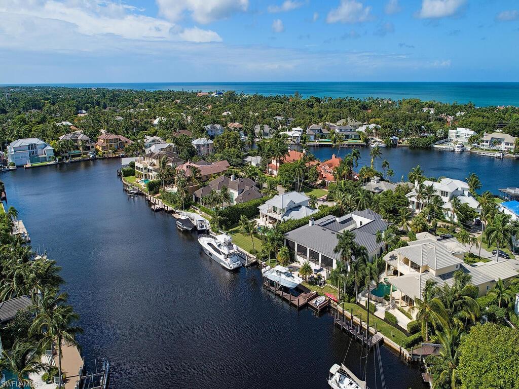 Location x 3 -- A boater, beach-goer and downtown enthusiast’s dream: Comfortable, well-maintained four-bedroom plus study home in Aqualane Shores with long southeastern water views. Just a four-block stroll to the beach and downtown Old Naples, on the quiet end of a large, open, navigable basin minutes by boat to Naples Bay and the Gulf of Mexico. There are so many possibilities with this home. Large, eat-in kitchen, and a formal dining area that doubles as second study, plus two spacious indoor living areas and gracious covered lanai overlooking the pool and spa. Three new a/c units in 2017, new kitchen appliances. Expansive master suite with dual walk-in closets and large master bath. The floorplan features separation between the three large en suite guest bedrooms, allowing plenty of privacy for family or guests.  Redecorate, renovate or rebuild:  the possibilities are endless.