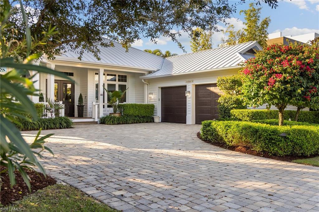 Positioned in one of Naples desired downtown neighborhoods, this beautifully appointed residence exudes timeless sophistication and ideal location, just a short stroll to the beach and the shimmering waters of the Gulf of Mexico. Designed for both comfort and style, this coastal-inspired home showcases a desirable split floor plan. An inviting front porch offers a tranquil and quiet setting to enjoy morning coffee and gather with neighbors and friends. The double-door entry welcomes you into an open foyer and elegant living room with soaring ceilings and a cozy fireplace. The gourmet kitchen, complete with a walk-in pantry and a casual morning room, leads to the formal dining area, creating a seamless flow for entertaining. An elegant primary suite featuring dual walk-in closets, a light-filled spa-like bath and private backyard access. Three spacious guest bedrooms, a private study, and three full and one-half baths provide ample space for family and guests. Expansive glass doors reveal a serene backyard retreat surrounded by lush tropical landscaping and covered lanai. The heated saltwater pool, with sun shelf and spa, complements the outdoor grilling station, offering a setting for relaxed afternoons or evening gatherings beneath Naples’ golden sunsets. Set on a meticulously landscaped 0.30-acre homesite with a side-load two-car garage, this residence blends privacy, elegance and convenience. Its premier location places you within a short distance of the new Four Seasons Naples Resort and just moments from fine dining, boutiques, galleries and theatres of downtown Naples. A rare opportunity to enjoy the best of luxury coastal living in Old Naples.