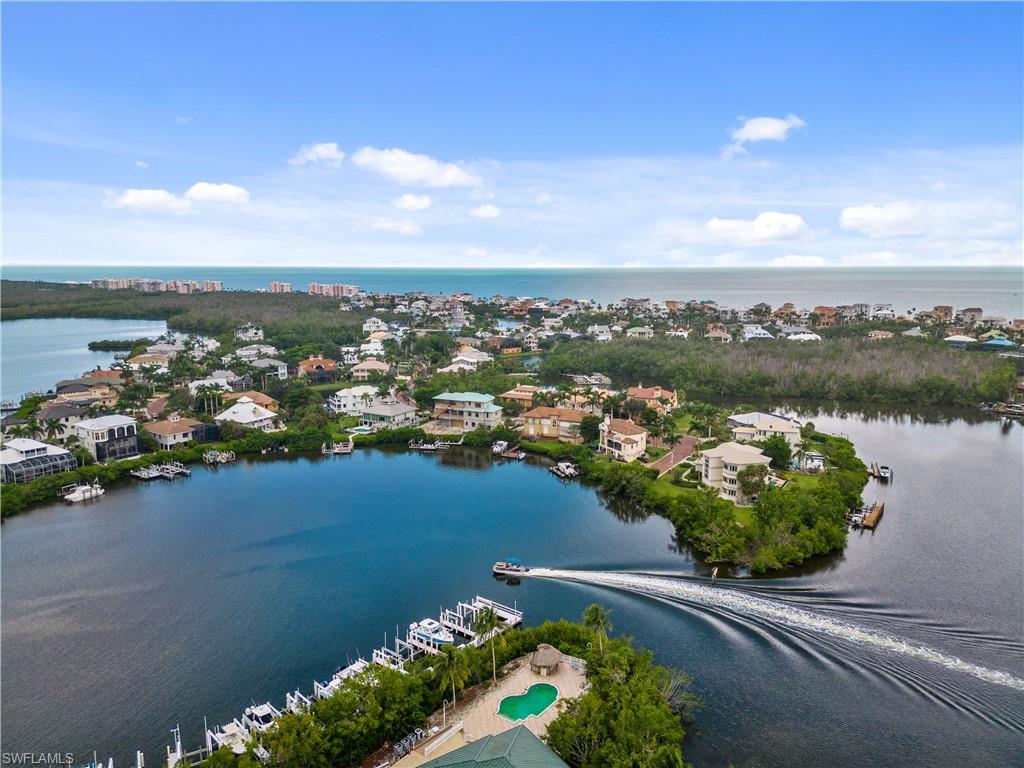 H11355 GULF-ACCESS HOME ON TWO LOTS WITH WRAPAROUND WIDE BAY VIEWS & A SHORT WALK TO THE BEACH! Perfectly located on a nearly ¾ acre corner point lot in the double-gated “Southport” neighborhood of Collier County’s premier “Barefoot Beach” community.  Delight in breathtaking bay views from nearly every window, magnificent sunsets over the pool/spa, & a 15-minute boat ride to the Gulf from your dual boat lifts! This 3 bedroom + den home boasts a open floor plan with natural light, high ceilings & a basketball court with the ability to transform into a pickleball court! Features a renovated chef's kitchen, whole house generator with a 1000-gal propane tank, room for an elevator & lower-level flex space. Spacious primary suite offers a sitting area to enjoy the breathtaking sunrises from the comfort of your bedroom, large walk-in closets & a separate shower & tub. Furnishings negotiable. The OPTIONAL in-community "Club at Barefoot" offers tennis, 2 restaurants, beachside food/bev/chair service & activities. Perfect location in Southport on the Bay in Barefoot Beach, close to fine dining & easy access to RSW Airport, Mercato & Waterside Shops. Only 15 miles to Naples 5th Avenue.
