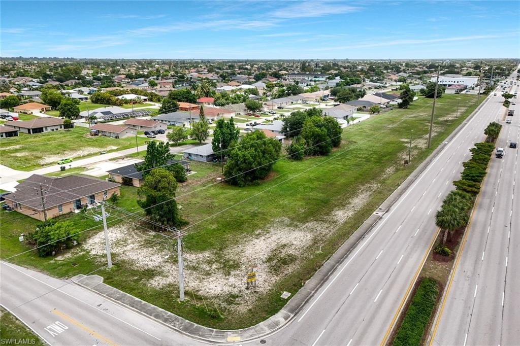 Prime commercial development opportunity located along Santa Barbara Blvd, one of Cape Coral’s most heavily traveled north-south corridors, with estimated TRAFFIC COUNTS exceeding 25,000–35,000 vehicles per day. This exceptional exposure provides maximum visibility for future retail, office, or mixed-use development and makes the site highly attractive to national and local tenants alike. This oversized 46,086 sq ft parcel features an impressive 341 feet of FRONTAGE, allowing for excellent access, signage, and curb appeal, and rear alley access. The property is ideally positioned within a dense residential population base and is surrounded by strong retail anchors, including Target and Lowe’s, as well as numerous restaurants, service businesses, and neighborhood retail centers that drive consistent consumer traffic throughout the day. The offer includes PLANS FOR A PROPOSED MULTI-TENANT RETAIL/OFFICE development, designed with modern architecture and strong street presence. The concept features multiple storefront units with expansive glass frontage. The site benefits from a strategic location near several schools, daycares, and family-oriented neighborhoods, including Cape Coral High School, which has over 2,000 students enrolled, creating strong daytime population and consistent traffic patterns. The proximity to educational facilities, along with nearby childcare centers and residential communities, makes this an ideal location for businesses catering to families, professionals, and daily convenience needs. Accessibility is a major advantage, with quick connectivity to Veterans Parkway, a key east-west corridor linking Cape Coral to Fort Myers and the greater Southwest Florida region. This ensures efficient traffic flow and enhances the property’s appeal for both customers and employees. From a development standpoint, the property is well-positioned to move forward quickly: City water and sewer are in place, All ASSESSMENTS are PAID in full, Not located in a flood zone, reducing insurance costs and development complexity. These factors significantly reduce upfront costs and timeline risk, making this a streamlined opportunity for developers and investors. The flexible development potential allows for a wide range of uses, including: Retail strip center , Medical or professional office, Restaurant or service-based tenants, Mixed-use commercial concept .With strong population growth in Cape Coral—now one of the fastest-growing cities in Florida—this corridor continues to see increasing demand for new commercial space.