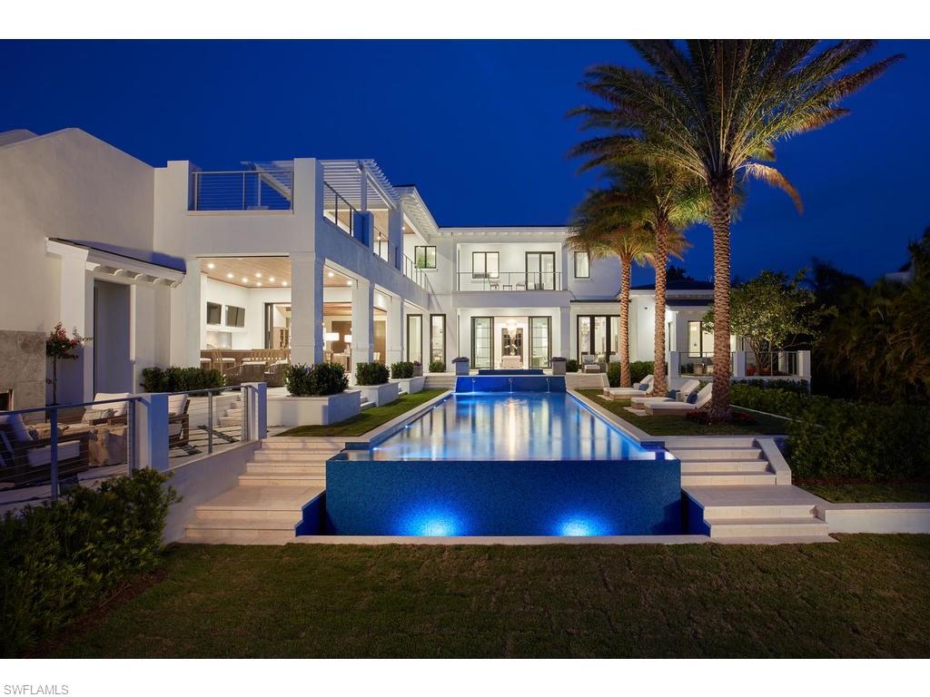Discover the meaning of luxury living at the lakeside paradise of “The Beach House” in the heart of Old Naples. This enchanting residence, steps from sugar sand beach, offers an impressive 12,000+ sq ft of indoor and outdoor spaces. The plan merges both an open and formal concept. The home features Legno Bastone wide plank floors, beamed ceilings, custom trim work and 10' impact windows & sliders. The chef’s kitchen has custom cabinets, Sub-Zero & Wolf appliances with twin islands. The butler’s pantry & wine room, with 2 Sub-Zero units & bar pass-through, set this residence above the rest. Multiple pantries, laundry room, large study, office, exercise room, media room & elevator. The formal living room, & separate family room open onto the terraced 850+/- sq ft zero edge pool that disappears into long lake views. Outdoor living includes a gas fireplace, hidden motorized screens, summer kitchen, bar & open air dining area. The main level master suite has his & hers oversized walk-in closets, a sitting area with a private lake view terrace & a spacious master bath. On the 2nd level, all 4 of the suite sized guest rooms have en-suite baths and walk in closets. Floor plan upon request.