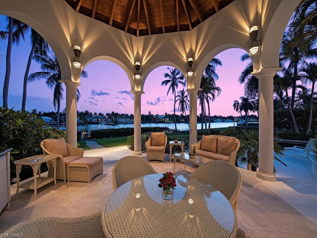 View the stunning sunsets over Treasure Cove.  This beautifully maintained property has long wide water views. Designed by Randall Stofft this wonderful floor plan allows you to enjoy the Port Royal lifestyle. The oversized lot allows for generous outdoor space and lawn area.   The Lanai has an outdoor kitchen and soaring wood ceilings. There are 4 bedrooms and a den.  The large master suite wing, has a sitting area and study.  There is also a separate guest quarters with kitchenette and its own entrance. The 48 ft. boat dock has 2 lifts.  Port Royal Club Membership Eligible