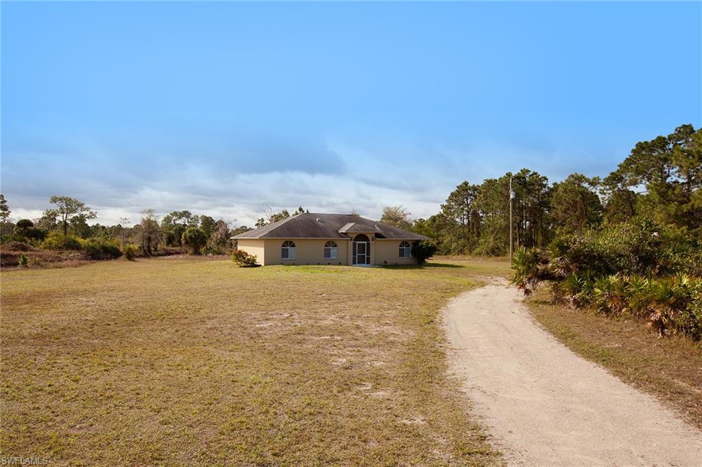 This spacious split floor plan, four-bedroom-plus-den, three-bath home offers low maintenance tile flooring throughout. This home features a double-entry door with screens for great natural breezes on beautiful Florida days, two air-conditioner units, a screened lanai and manual shutters. The light and bright kitchen boasts white countertops and appliances. Over 5 acres of property on a canal in a very private location. This home is being offered as-is.