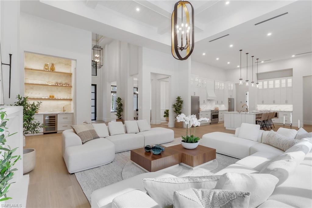 NOW FULLY FURNISHED!!! This Logan Woods estate rests on 2.27 acres of 100% upland, offering the ultimate blend of luxury, privacy, and accessibility. Logan Woods is one of Naples’ most desirable neighborhoods, valued for its quiet charm and freedom from HOA restrictions—all just minutes from I-75, Physician’s Regional Hospital, Mercato, Seed to Table, fine dining, and Naples’ world-famous beaches. Inside, discover soaring ceilings, wood-look porcelain tile, and a thoughtfully designed open-concept floor plan with clean modern finishes. The main living area showcases a gas fireplace and wet bar, creating a warm and elevated atmosphere. The chef’s kitchen offers custom cabinetry, gas range, walk-in pantry, and an oversized island. A mud room, 3-car garage, and spacious laundry room add everyday convenience to the home’s design.
The primary suite blends indoor-outdoor living with private access to the screened lanai, and the spa-like bath features dual showers, a soaking tub, and double vanities. Each additional bedroom includes an en-suite bath and walk-in closet. Grand sliding doors—the tallest allowed by code in Collier County—open to a fully screened lanai with summer kitchen, outdoor gas fireplace, and a sparkling pool and spa, offering the perfect setting for cozy evenings under the stars.