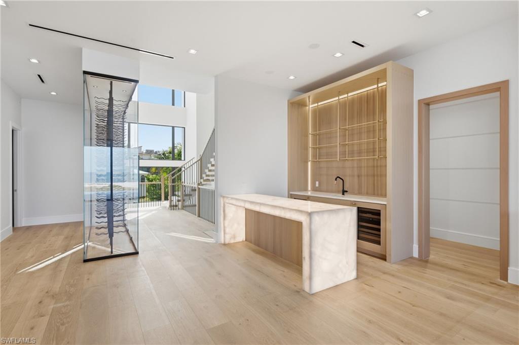 A new benchmark in luxury is nearing completion on Fort Myers Beach. Set on a truly extraordinary 80x400-foot beachfront homesite, this one-of-a-kind Alair custom residence is poised to redefine coastal living on the island. Expected to be completed soon and offered fully furnished, this spectacular estate has been curated by a top-tier designer, delivering a rare opportunity to step into a fully realized vision of refined beachfront luxury.

Perfectly positioned on the coveted south end of Fort Myers Beach, this remarkable Gulf-front residence enjoys one of the island’s most unique settings—true beachfront living without being directly on Estero Boulevard—offering both privacy and prestige in an exceptional location. Finished in authentic tabby, a timeless blend of shells and concrete that honors the area’s coastal heritage, the home makes an immediate architectural statement while embracing the elegance of modern design.

Inside, soaring 12-foot ceilings, walls of impact-rated glass, and expansive 10-foot sliding doors create a dramatic yet welcoming atmosphere, perfectly framing sweeping Gulf views and effortless indoor-outdoor living. Riva Elite European white oak flooring, custom millwork, floating beams, shiplap accents, and thoughtfully designed ceilings bring warmth, texture, and sophistication throughout.

The chef’s kitchen is a true showpiece, featuring a premium Sub-Zero, Wolf, and Cove appliance suite, bespoke cabinetry, and striking natural stone surfaces designed for both everyday comfort and elevated entertaining. An oversized laundry room and separate caterer’s kitchen add another layer of functionality for seamless hosting.

The home offers five bedrooms, five full baths, and three half baths, including four beautifully appointed guest suites. The primary suite is designed as a private sanctuary, complete with custom architectural detailing, two oversized boutique-style walk-in closets with built-in cabinetry, dual water closets, and a spa-inspired bath with suspended designer mirrors and exceptional natural light.

An extraordinary collection of luxury features sets this residence apart, including a temperature-controlled glass wine display for over 600 bottles, two laundry rooms, a main-level entertaining bar, an upper-level morning bar, Lutron lighting controls, Savant home automation, a private elevator, LED-lit shower niches, and illuminated toe-kicks throughout.

Outdoor living is just as impressive, offering a resort-style experience with an elevated pool featuring integrated fire elements, expansive lounging areas, a full outdoor kitchen, and a stunning outdoor fireplace finished in leathered Black Diamond quartzite—all positioned to capture unforgettable sunsets over the Gulf.

Rare in scale, exceptional in design, and nearly ready for its debut, this fully furnished beachfront masterpiece is more than a home—it is a statement property setting a new tone for luxury real estate on Fort Myers Beach.