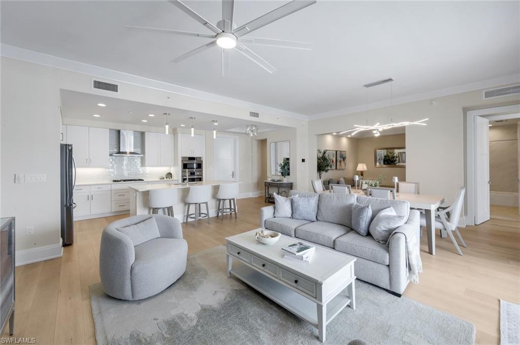 Experience the pinnacle of downtown Naples living in this rarely available penthouse-level residence in Naples Square III. Located on the top (5th) floor, this sought-after "Chatham" floor plan offers 1,883 square feet of thoughtfully designed living space with 2 bedrooms plus a den, 2 full baths, and a powder room. Western exposure fills the home with natural light, while the spacious private terrace overlooks the beautifully landscaped courtyard.

Recently installed engineered hardwood flooring enhances the home's warm coastal aesthetic and adds timeless elegance throughout the main living areas. Designed for both comfort and entertaining, the open-concept floor plan features a gourmet kitchen with stainless steel appliances, quartz countertops, a subway tile backsplash, white Shaker cabinetry, and an oversized island overlooking the great room. The split-bedroom layout provides exceptional privacy for owners and guests alike.

Residents enjoy resort-style amenities, including a pool and spa, outdoor grilling areas, a fitness center, billiards, and a stylish clubroom. Additional conveniences include two garage parking spaces (one deeded), a humidity-controlled storage unit, and secure bike storage.

Ideally located in the heart of the Naples Design District, this exceptional residence is just steps from Gulfshore Playhouse, Baker Park, and the shopping and dining of Fifth Avenue South, with Naples' white-sand beaches only minutes away. Combining the privacy of a top-floor location with walkable access to Naples' premier attractions, this residence offers the best of luxury urban living.