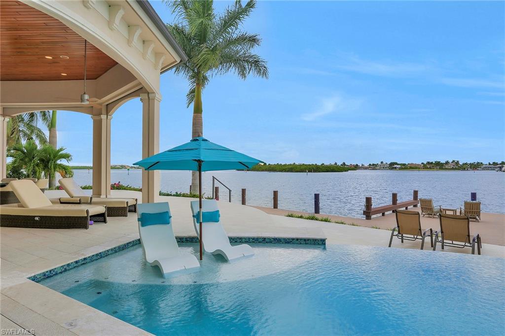 This spectacular Coastal Contemporary home, with jaw dropping views from every room, sits on a tip lot in the prestigious Tigertail area of Marco Island. Boasting 173’ on water direct built in 2015. This magnificent estate will take your breath away from the moment you walk in! This 2-story custom built home is well appointed with marble and tile floors, soaring 15’ ceilings, with incredible craftsmanship throughout, completes this lavish interior space!  With over 4800 SF under air this 4Bd/4.2Baths, has a huge great room, den, and upstairs media room with wet bar.  Custom gourmet kitchen includes quartz counters and Thermador appliances, offering stunning views from every window!  Impact doors and windows complete with electric storm shutters and screens.  A true boaters delight, seconds to open water, boasts jet ski and boat lifts with wrap around deck. The outdoor living space has multiple entertaining areas, an outdoor kitchen, centered around the infinity edge pool and spa!  Built for the most discerning buyer, this home has it all!  Being sold turnkey furnished!