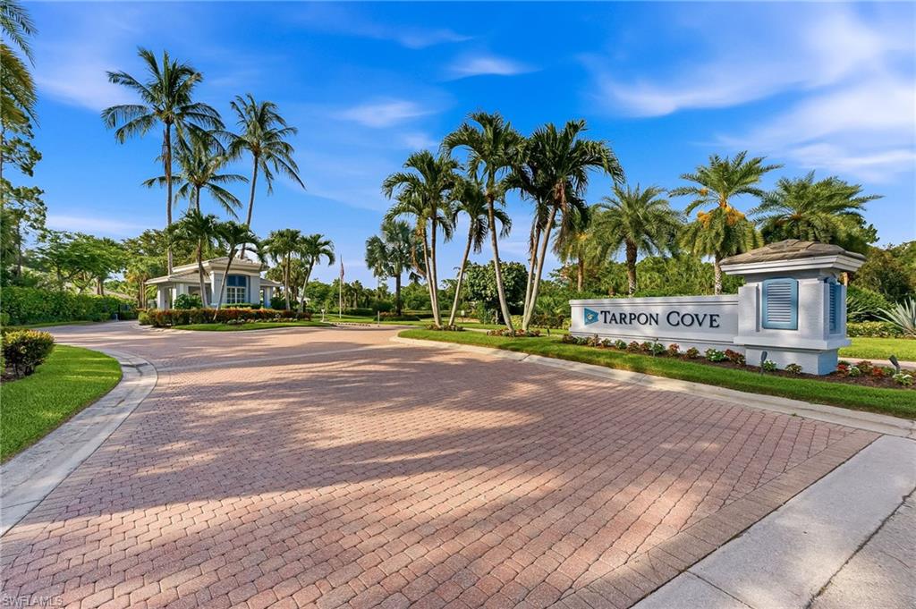 Tarpon Cove is a highly sought after gated community.  A charming, semi-private garden courtyard entrance creates a warm and welcoming arrival. This beautifully decorated and well maintained second floor coach home has 2 bedrooms/two baths--with den.  Den has a closet..(Third bedroom being utilized as a den at this time).  Soaring ceilings throughout.  Enjoy the private spacious lanai with tranquil lake views.  Eastern sunrise exposure.  Multi-panel sliding glass doors open the great room to the lanai.  Additional sliding glass doors create indoor-outdoor living making this unit perfect for entertaining.  The bright kitchen has stainless steel appliances, attractive counter tops with complimentary  stone backsplash.  Primary suite enjoys peaceful lake views, lanai access, dual raised vessel sinks, and a glass enclosed shower.  The guest bedroom accommodates a queen size bed.  The adjacent guest bath features a raised vessel sink with a glass counter top and a tub/shower combination. Flooring is porcelain plank tile throughout. Plantation shutters, neutral finishes, separate laundry room.   Air conditioner is approximately 2 1/2 years old. Tastefully decorated this home has nice upgrades.  Sold furnished(with exclusions). Attached garage is climate controlled with A/C.   Tarpon Cove residents may join the nearby Tarpon Cove and Racquet Club.  The membership offers tennis, fitness, bocce, dining and a private beach shuttle.  Your own community enjoys private clubhouse, pools and spa,  and work out center.  Located close to shopping, dining, beach, and more.