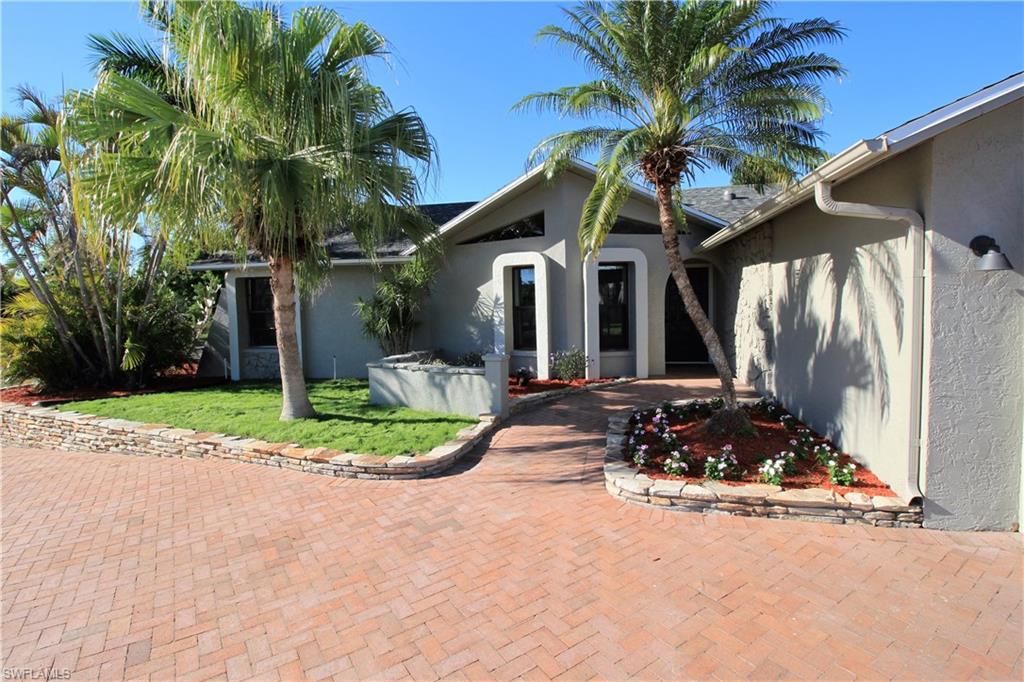 Completely remodeled 3/2/2. Open concept with vaulted ceilings and tons of natural light. Too many improvements to list including: new roof just completed, brand new kitchen featuring shaker style cabinets, large island, farmhouse sink, subway tile backsplash and new stainless steel appliances. New bathrooms with floating vanities and modern fixtures. Master bath has walk in shower with frameless glass door. Master bedroom features stylish wood accent wall. Home features 4 sets of patio doors leading to nearly 800 sq. ft. lanai for desirable indoor outdoor living. Private backyard with lush mature landscaping. City utilities are in and all assessments are paid. Other features include oversize sliding barn door, new light fixtures and ceiling fans, imported Italian tile throughout. Freshly painted inside and out. Great neighborhood, located across the street from $400k gulf access canal homes. Entire attic has been spray foamed for better energy efficiency and more usable storage space. Home was re-piped in 2007. Outdoor kitchen has been roughed in and is ready for your finishes.