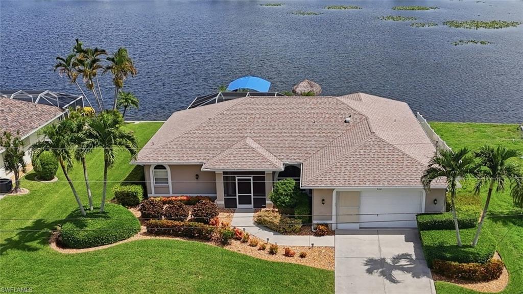Welcome to lakefront living on beautiful Lake Saratoga, one of Cape Coral's most sought-after freshwater lakes. 

Offering breathtaking wide-water views, direct boating access to miles of interconnected lakes and canals, and best of all, this waterfront property is located outside of a flood zone, providing peace of mind. 

This meticulously maintained 3-bedroom plus den, 2-bath home was thoughtfully designed to make the most of its exceptional waterfront setting. Expansive windows and multiple sets of pocketing sliding glass doors flood the home with natural light while seamlessly connecting the interior living spaces to the expansive screened lanai and pool, creating one continuous living and entertaining space overlooking beautiful Lake Saratoga.

The open floor plan features crown molding, recessed lighting, and spacious living areas centered around the picturesque lake views. The kitchen is both functional and inviting with custom wood cabinetry, granite countertops, under-cabinet lighting, a custom tile backsplash, breakfast bar, center island with additional storage, built-in wine rack, and bar area—making it the perfect gathering place for family and friends. The den provides flexible space for a home office, hobby room, or additional guest accommodations.

The primary suite serves as a peaceful retreat with pocketing sliding glass doors opening directly to the lanai, allowing you to wake up to tranquil lake views each morning. The ensuite bath features a jetted soaking tub, walk-in shower, and linen closet, while the split-bedroom floor plan offers privacy and comfort for both owners and guests.

Step outside to your own private waterfront oasis where the expansive screened lanai, sparkling pool with its decorative dolphin tile inlay, concrete dock and wooden dock, covered 4,000-pound boat lift, and charming tiki hut invite you to enjoy everything Lake Saratoga has to offer. Whether you're boating, fishing, kayaking, paddleboarding, or simply relaxing by the water, you'll appreciate the endless opportunities to explore Cape Coral's interconnected freshwater lake system from your own backyard.

Numerous recent improvements add exceptional value, including a newer roof, HVAC system, boat dock, 4,000-pound boat lift, lanai screens, and a mini-split air conditioning system in the garage, creating a comfortable climate-controlled space for hobbies, projects, or additional storage. Accordion shutters protect much of the home, providing added storm protection and peace of mind. Furniture is negotiable, with the seller preferring to sell the home furnished, making your transition to lakefront living even easier.

From morning coffee overlooking the peaceful waters of Lake Saratoga to afternoons on the boat and evenings spent relaxing poolside beneath the tiki hut, this is more than a home—it's where lasting memories are made and the very best of Southwest Florida waterfront living begins.