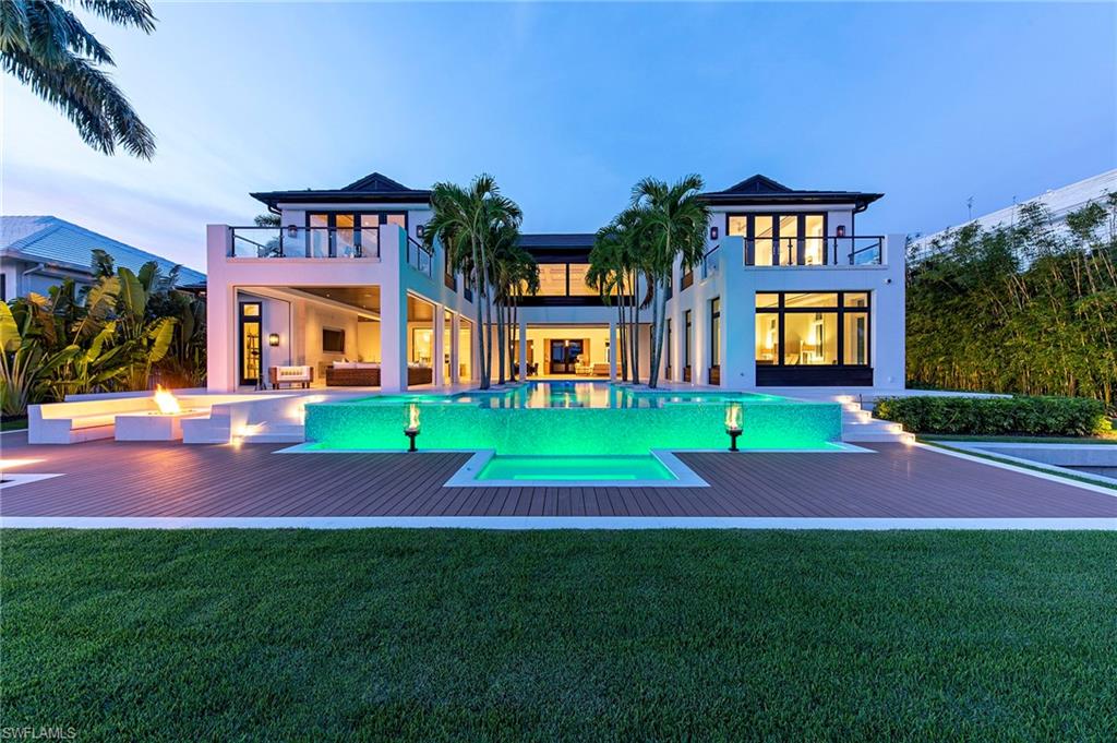 Conceived and constructed by one of the finest teams in luxury home building, this A. Vernon Allen-John Kukk-Lisa Kahn collaborative has delivered a stunning new construction opportunity to Aqualane Shores.  Just beyond the stately front gate and through the massive Mahogany entry doors lies an expansive southern exposure home with open spaces and an adaptable floorplan. Owners will enjoy 2 master suites, 4 aditional guest bedrooms, 4 terraces, a theater room, 2 staircases, a wine room, and a freestanding elevator. Built with uncompromising attention to detail this home also includes:  the Lutron lighting system, 10’ sliders that fully pocket, custom Walnut cabinetry, “his and hers” master bathrooms, a steam shower, Titan electric screens and shutters, 2 linear fireplaces, a firepit with built-in seating, a Generac generator, a 1000 gallon propane tank, and is available furnished. The centerpiece of the home is a dramatic pool flanked by 6 specimen palms, that emerges from within the home's envelope and culminates with multiple sun decks and an infinity edge.  With no-bridge access to the Gulf and walkability to the beach and downtown, this home is the ultimate Naples residence.