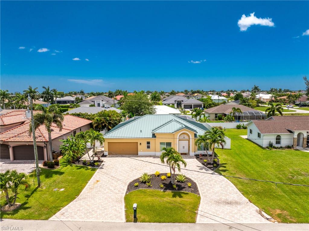 This 2,019-square-foot Cape Coral home features 3 Bedrooms, 2 Bathrooms, a dedicated OFFICE/DEN, and 9FT CEILINGS throughout. The exterior includes a CIRCULAR PAVERED DRIVEWAY, a TWO-CAR GARAGE, a durable METAL ROOF (Replaced February 2020), a NEW IRRIGATION SYSTEM, a 6ft VINYL PRIVACY FENCE, and beautiful landscaping. Entering through the FRONT FRENCH DOORS reveals a spacious floor plan with TILE FLOORING throughout the main living areas and LUXURY VINYL FLOORING in the bedrooms, office, and dining spaces. The front of the home offers a versatile layout featuring an open area for a formal dining or living room alongside a private FLEX ROOM well-suited for a home office, den, game room, or hobby space. Some photos have been virtually staged to demonstrate potential furniture layouts.

The kitchen features all stainless steel appliances, granite countertops, white cabinetry, and a breakfast bar. This central space flows directly into the secondary open living area, which provides direct access out to the pool deck through a glass door. The PRIMARY BEDROOM includes TWO WALK-IN CLOSETS and generous layout space for large furniture. BOTH BATHROOMS RECENTLY FULLY REMODELED (2025). The primary bathroom is equipped with a modern DUAL VANITY countertop and a custom tiled WALK-IN SHOWER, while the guest bathroom includes a tub/shower combination and direct ACCESS TO THE POOL. An OVERSIZED LAUNDRY ROOM completes the interior, offering substantial built-in cabinetry for extra pantry and storage space.

The ultimate outdoor living area consists of a covered concrete lanai opening to a SCREENED ENCLOSURE on a full BRICK-PAVER POOL DECK perfect for sunbathing. The OVERSIZED, HEATED POOL features a central side-wall WATERFALL FEATURE, complemented by an IN-GROUND HOT TUB that cascades directly into the pool. Sitting on a 10,629-square-foot lot with a complete PROPERTY SURVEY AVAILABLE, this home is located just under 3 miles from the Pelican Baseball Complex boat ramp for freshwater canal access, and roughly 5 miles from Cape Harbour Marina for quick Gulf access. This property is positioned in CAPE CORAL'S RAPIDLY GROWING AREA, ensuring all essential shopping, dining, and daily conveniences are located just minutes away.