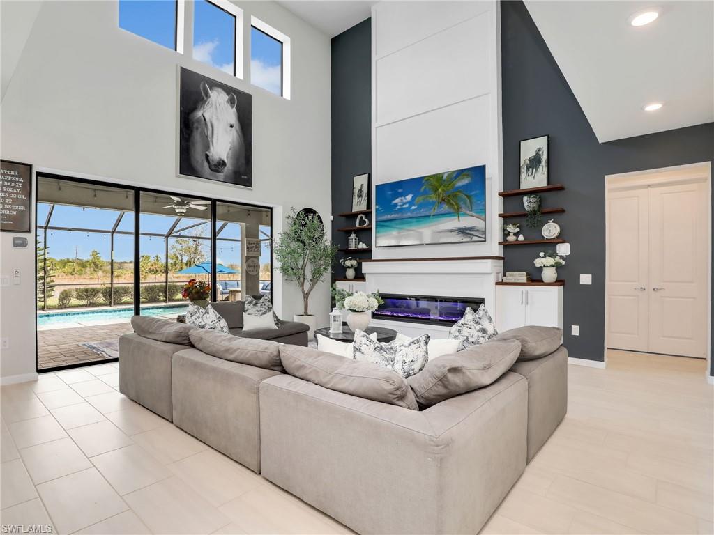 Welcome Home to this exceptional luxury estate offering one of the most desirable floor plans in all of The Place at Corkscrew. Priced to sell, this stunning Heatherton model presents an extraordinary opportunity to own over 4,600 square feet of beautifully upgraded living space featuring the highly sought-after design with two luxurious primary suites—ideal for multi-generational living, extended guests, or those seeking ultimate flexibility. From the moment you arrive, the impressive front elevation, welcoming front porch, and oversized driveway accommodating up to 12 vehicles create an unforgettable first impression. Inside, you'll discover 6 spacious bedrooms, 5.5 bathrooms, and thoughtfully designed living spaces that seamlessly blend elegance, comfort, and functionality. Luxury finishes are showcased throughout, including designer tile flooring, upgraded wood stair railings, custom feature walls, an elegant electric fireplace, central vacuum system, home security system, Wi-Fi extenders, and countless premium upgrades that elevate everyday living. The heart of the home is a chef-inspired gourmet kitchen designed for entertaining on any scale. Featuring an expanded custom layout with additional cabinetry, abundant quartz countertops, stainless steel appliances, a vented microwave, oversized center island with farmhouse sink, and exceptional storage, this kitchen is as beautiful as it is functional. Step outside into your own private resort. The spectacular heated saltwater pool and spa are surrounded by an expansive screened lanai with professional landscape lighting, creating an incredible setting for year-round entertaining. The fully equipped outdoor kitchen, generous covered living areas, and peaceful preserve views offer exceptional privacy while capturing the very best of the Southwest Florida lifestyle. Living in The Place at Corkscrew means enjoying one of Southwest Florida's premier resort-style communities. Residents have access to world-class amenities including a spectacular resort pool with a 100-foot waterslide, waterfalls, spa, full-service restaurant and bars, adult-only bourbon bar, café, marketplace, two-story fitness center, pickleball, tennis, bocce, basketball, dog park, playground, childcare center, and an active social calendar. Ideally located just minutes from RSW International Airport, Florida Gulf Coast University, Gulf Coast Town Center, Miromar Outlets, Coconut Point, championship golf, fine dining, and Southwest Florida's world-renowned beaches, this exceptional residence offers luxury, lifestyle, and value in one remarkable package.